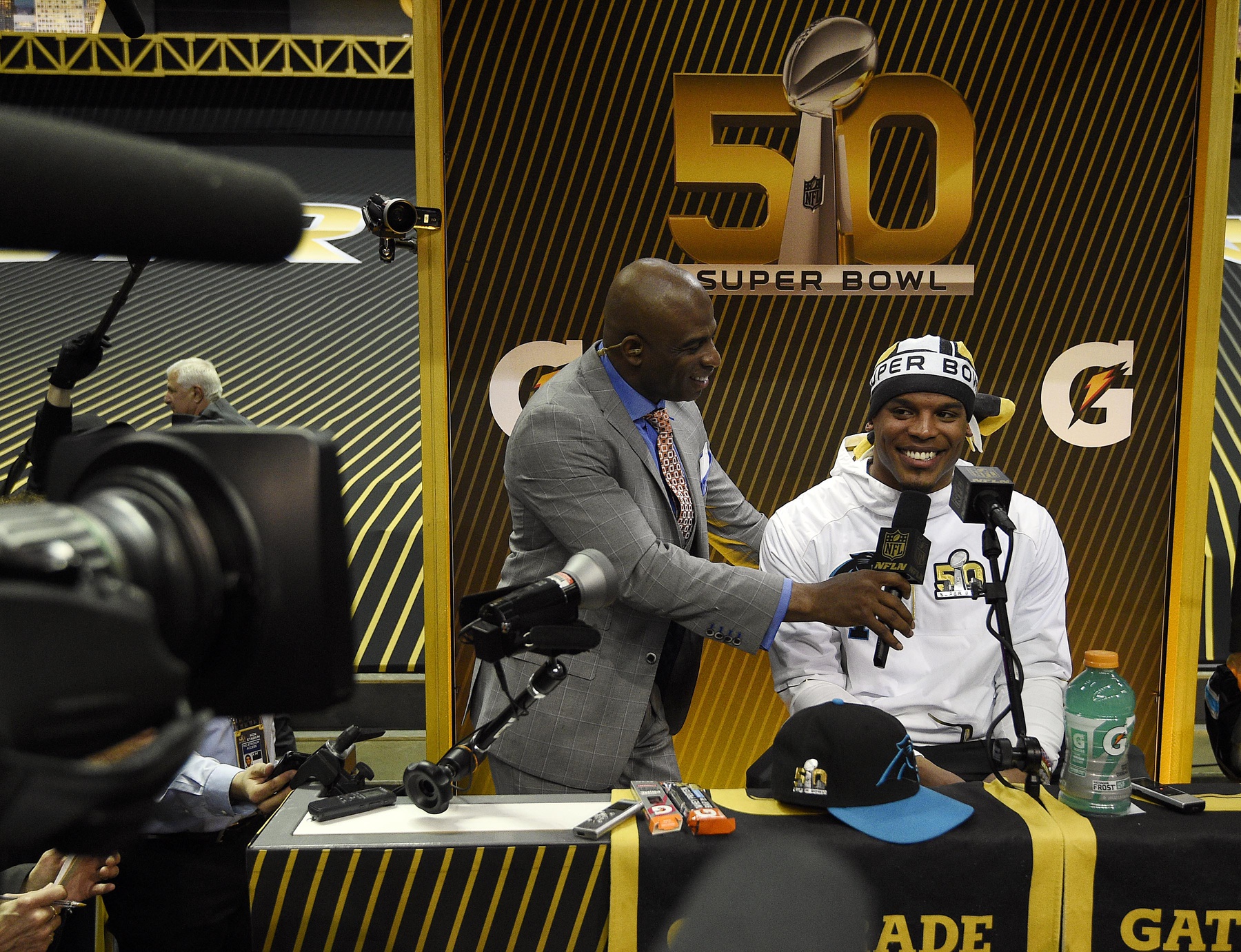 Carolina Panthers quarterback Cam Newton (1) is interviewed by NFL network analyst Deion Sanders during Super Bowl 50 Opening Night media day at SAP Center.
