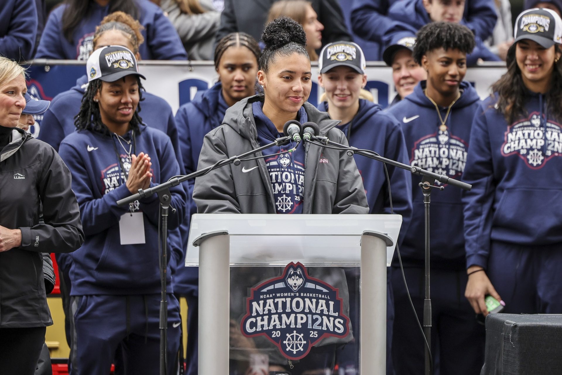 UConn student-athlete Azzi Fudd addresses the crowd while her teammates UConn student-athletes Paige Bueckers,  KK Arnold, Sarah Strong  and Ayanna Patterson look on during the Final Four champions victory parade and rally outside of the XL Center in Hartford, CT.