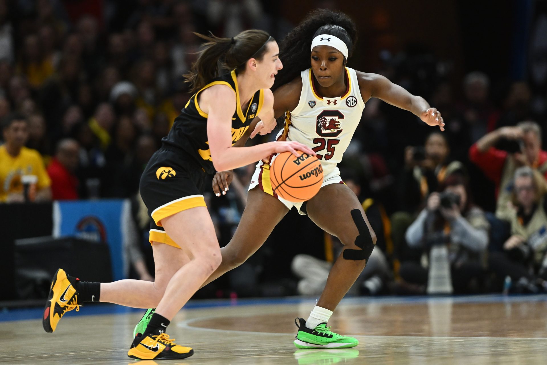 Iowa Hawkeyes guard Caitlin Clark (22) dribbles the ball against South Carolina Gamecocks guard Raven Johnson (25) in the finals of the Final Four of the womens 2024 NCAA Tournament  at Rocket Mortgage FieldHouse.