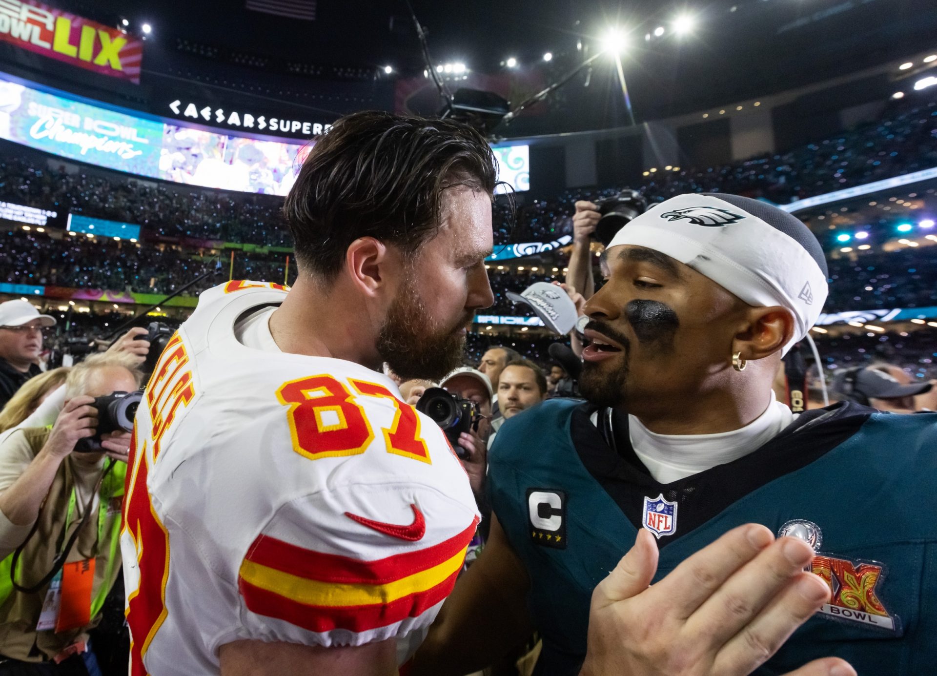 Kansas City Chiefs tight end Travis Kelce (87) congratulates Philadelphia Eagles quarterback Jalen Hurts (1) following Super Bowl LIX at Ceasars Superdome.