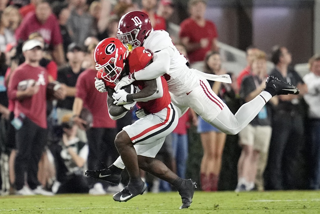 Alabama Crimson Tide linebacker Justin Jefferson (10) tackles Georgia Bulldogs running back Nate Frazier (3) in the first half at Sanford Stadium.