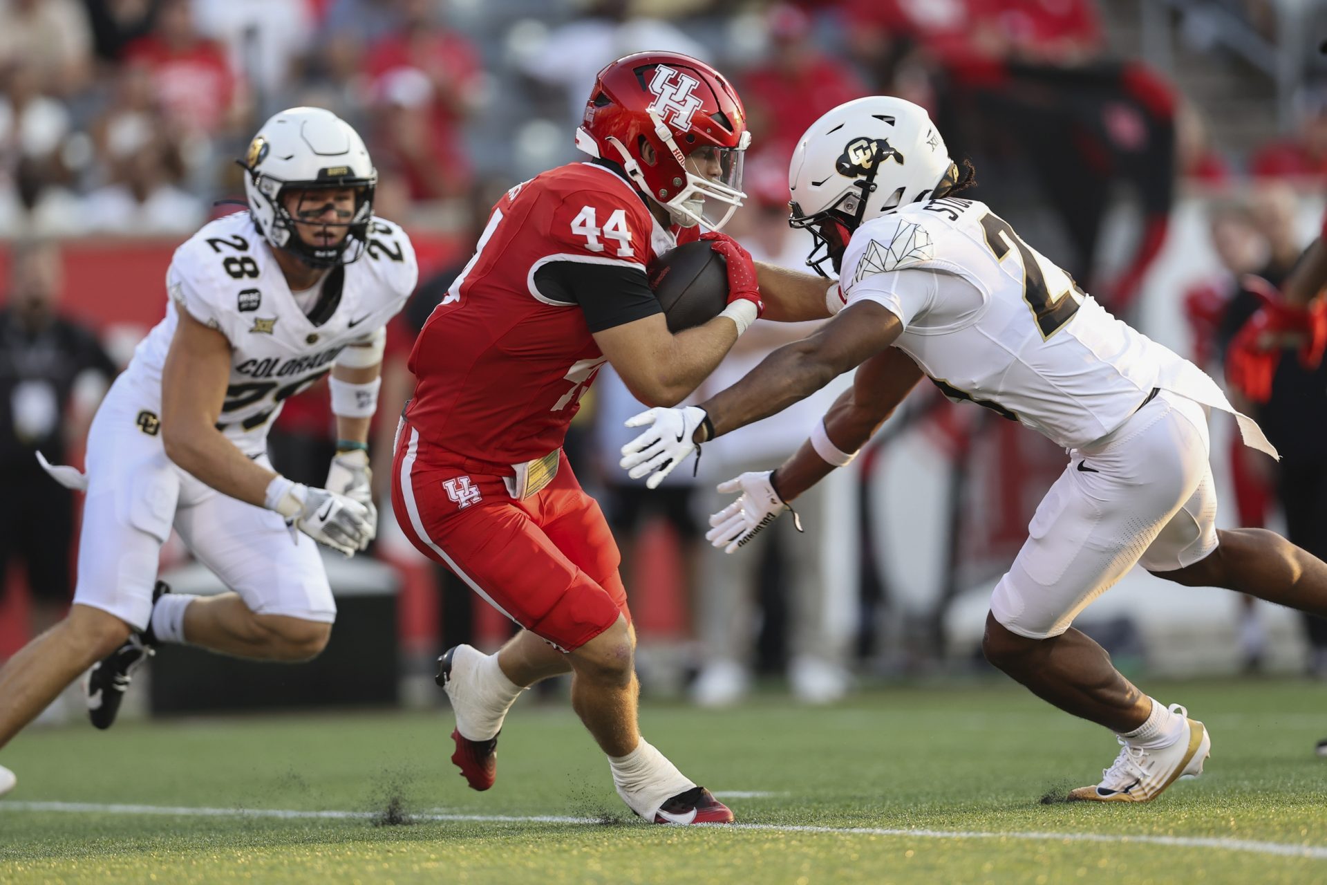Houston Cougars running back Dean Connors (44) runs witht the ball as Colorado Buffaloes safety Carter Stoutmire (23) attempts to make a tackle during the first quarter at TDECU Stadium.