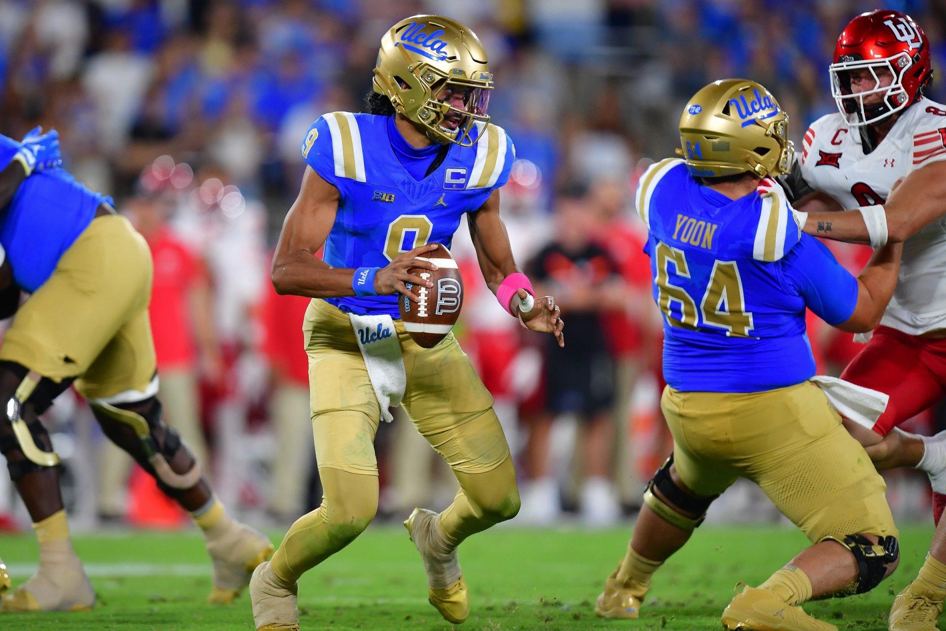 UCLA Bruins quarterback Nico Iamaleava (9) moves out to pass as offensive lineman Sam Yoon (64) provides coverage against Utah Utes linebacker Lander Barton (8) during the second half at Rose Bowl.