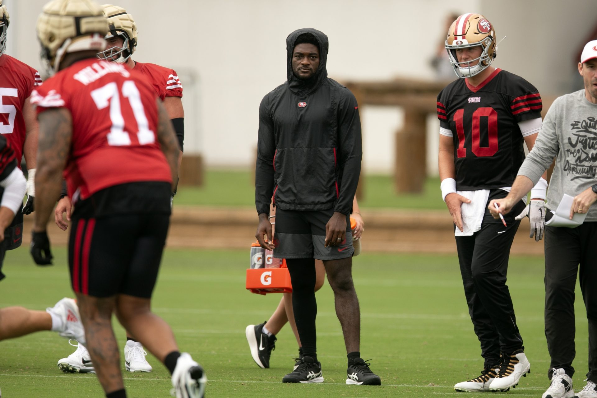 San Francisco 49ers wide receiver Brandon Aiyuk (in black hoodie) watches his teammates work out during the second day of training camp.