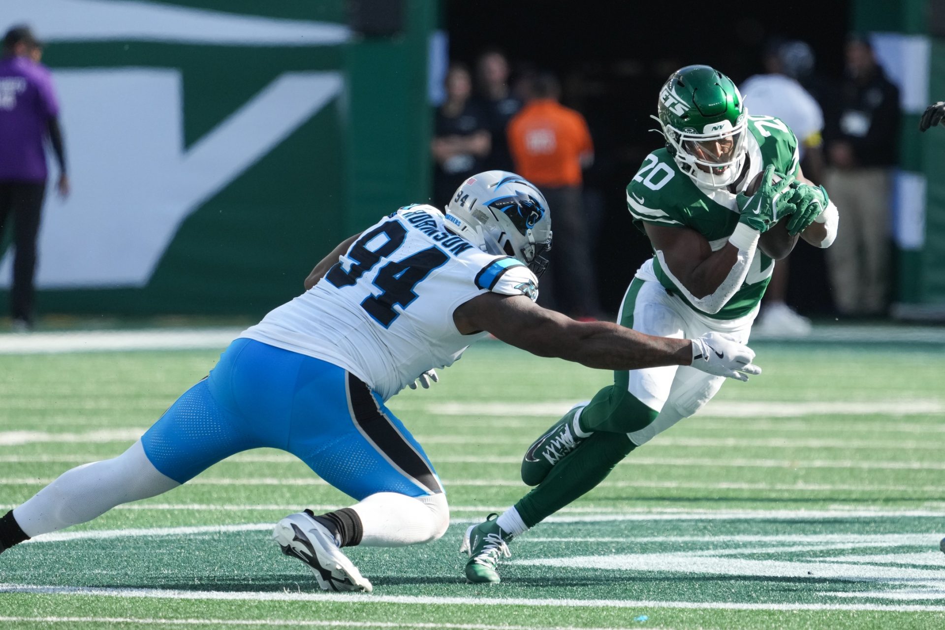 New York Jets running back Breece Hall (20) runs with the ball while being defended by Carolina Panthers defensive end A'Shawn Robinson (94) in the third quarter at MetLife Stadium.