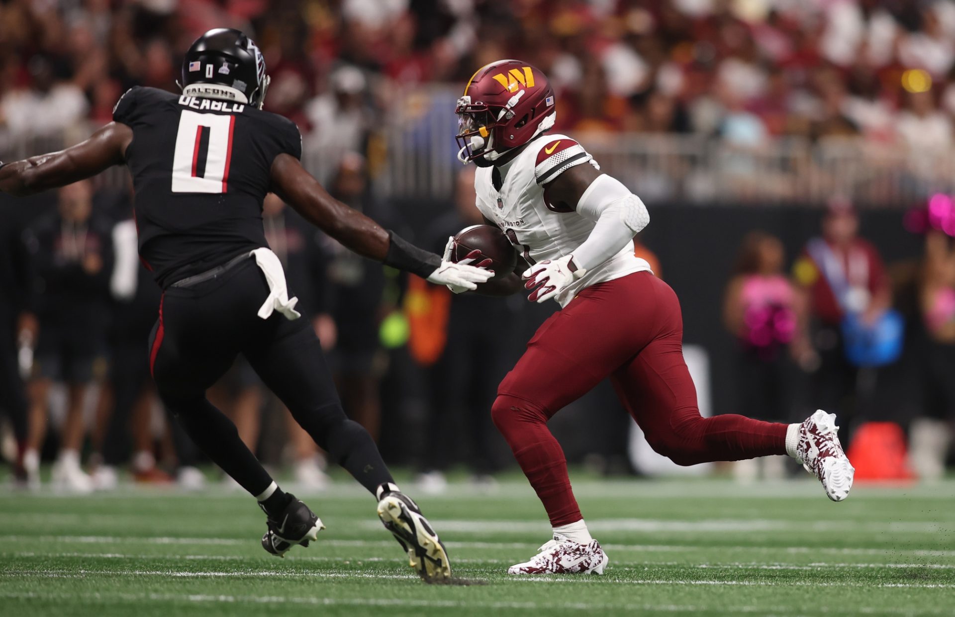 Washington Commanders wide receiver Deebo Samuel Sr. (1) runs against Atlanta Falcons linebacker Divine Deablo (0) during the first quarter at Mercedes-Benz Stadium.