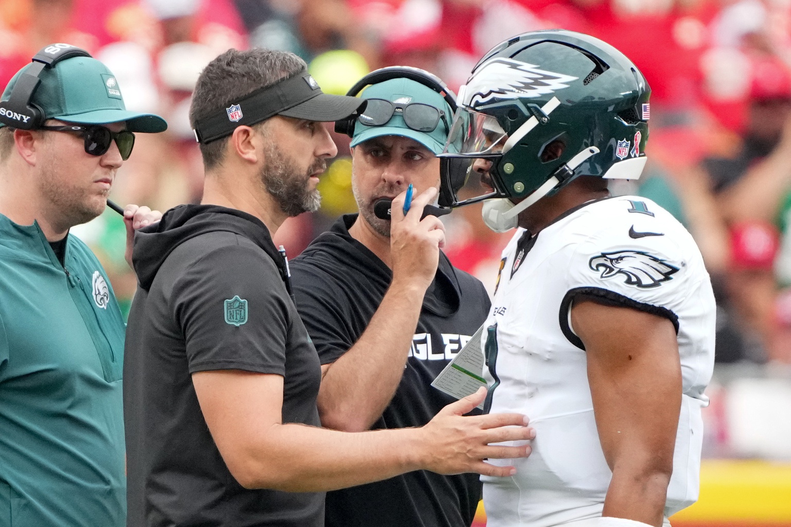 Philadelphia Eagles head coach Nick Sirianni and offenisve coordinator Kevin Patullo speak with Philadelphia Eagles quarterback Jalen Hurts (1) during the second quarter of the game against the Kansas City Chiefs at GEHA Field at Arrowhead Stadium.