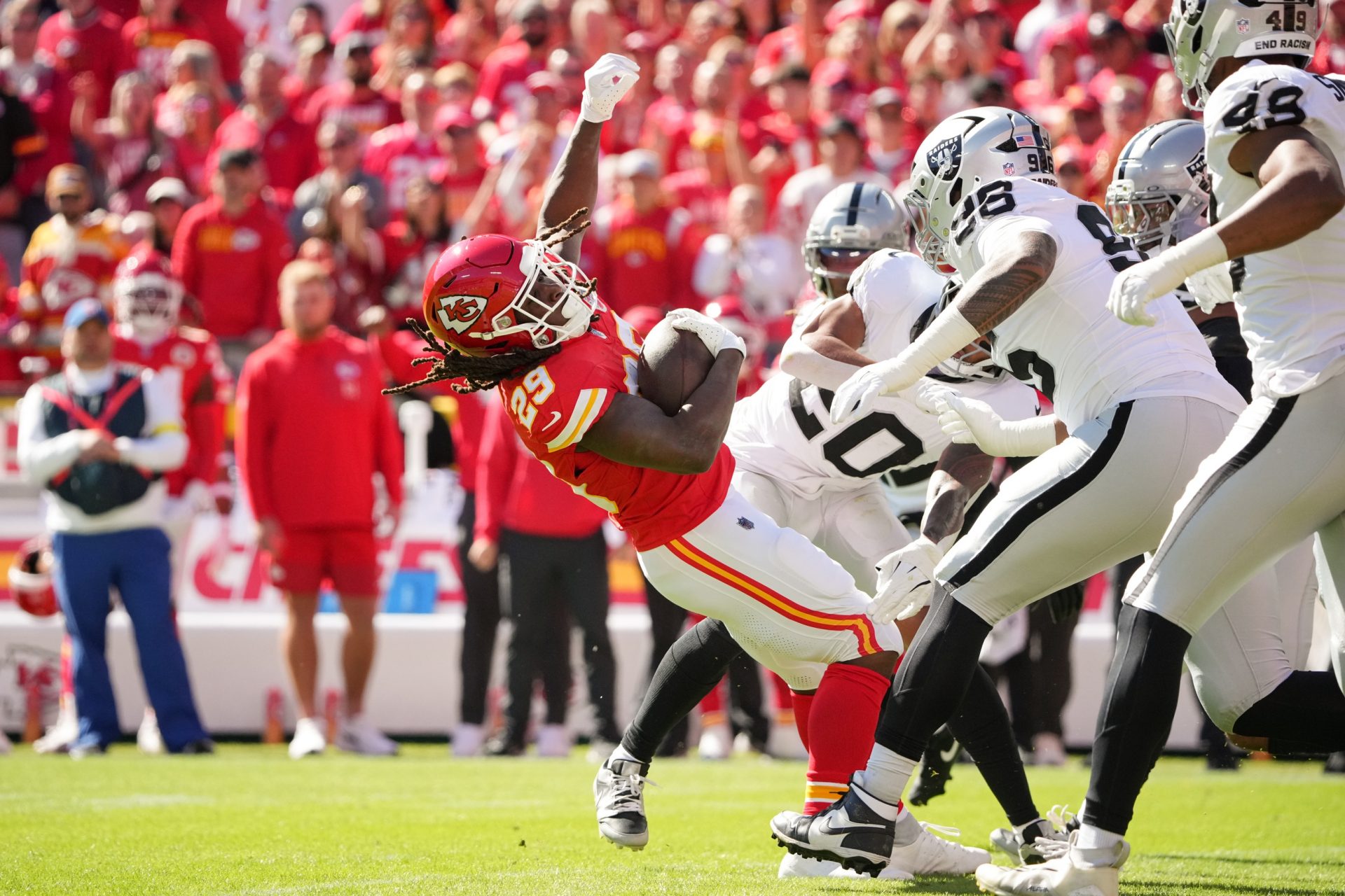 Las Vegas Raiders safety Isaiah Pola-Mao (20) and defensive end Maxx Crosby (98) tackle Kansas City Chiefs running back Kareem Hunt (29) during the first quarter of the game at GEHA Field at Arrowhead Stadium.