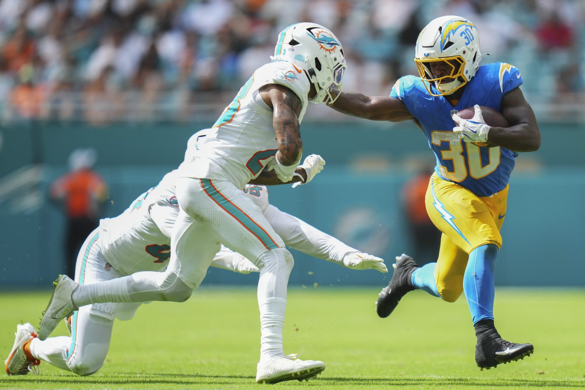 Miami Dolphins cornerback Jack Jones (23) tackles Los Angeles Chargers running back Kimani Vidal (30) during the fourth quarter at Hard Rock Stadium.