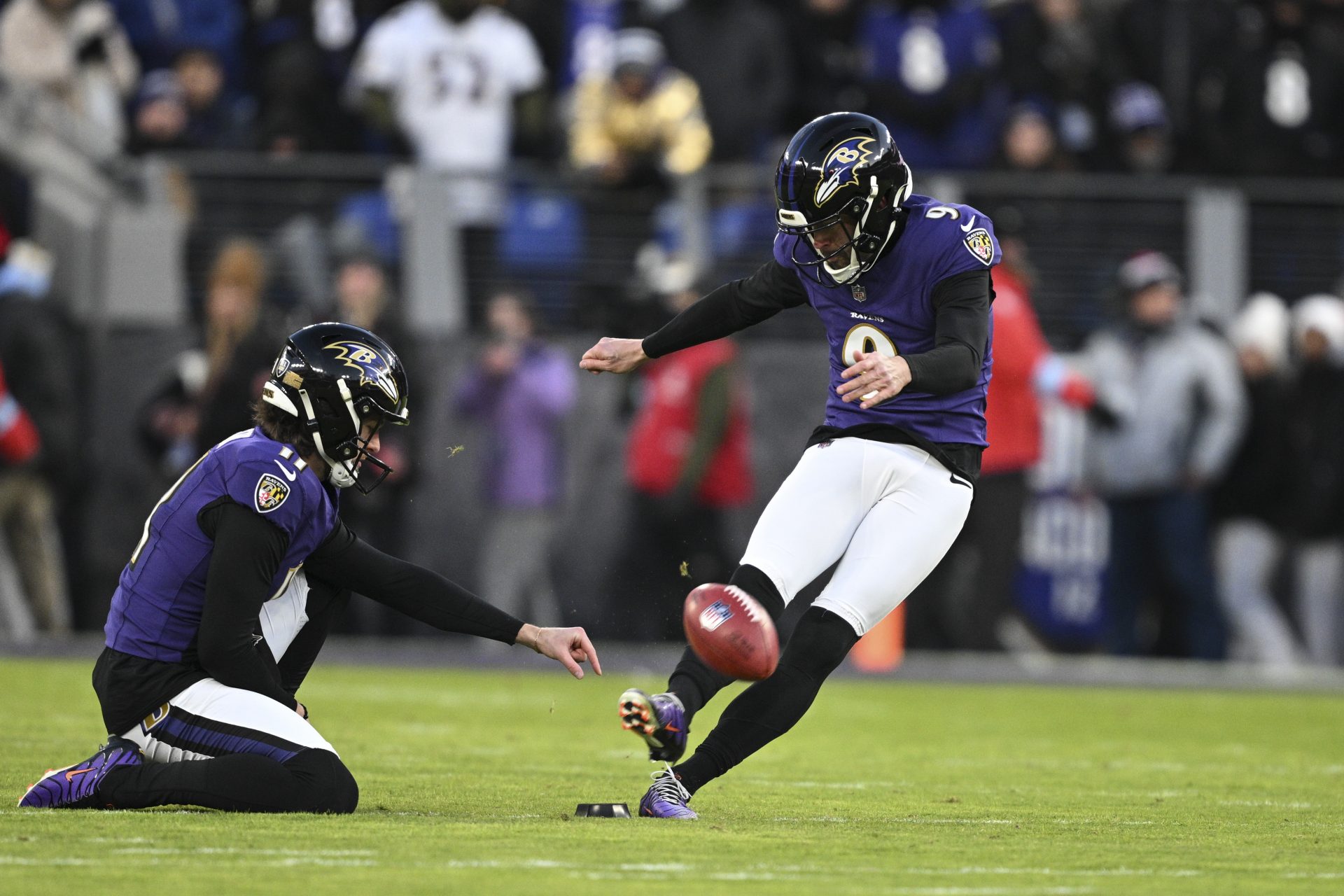 Baltimore Ravens place kicker Justin Tucker (9) kicks off as  punter Jordan Stout (11) holds during the first quarter against the Cleveland Browns at M&T Bank Stadium.