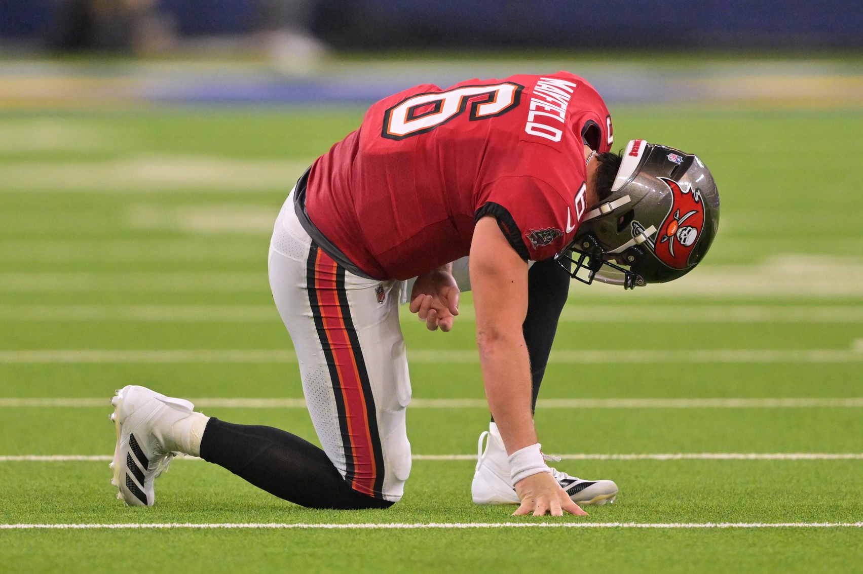 Tampa Bay Buccaneers quarterback Baker Mayfield (6) kneels on the field with an apparent injury against the Los Angeles Rams during the second quarter at SoFi Stadium.