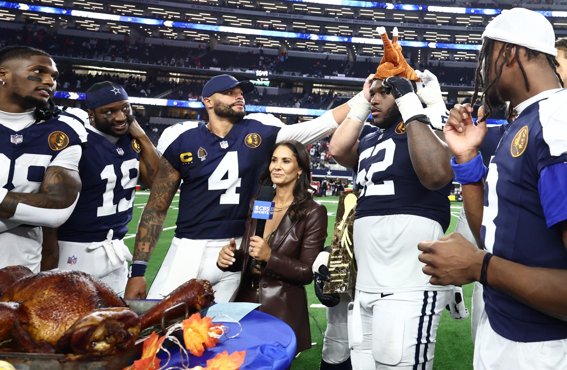 Dallas Cowboys quarterback Dak Prescott (4) and Dallas Cowboys guard Tyler Booker (52) celebrate with a turkey after the game against the Kansas City Chiefs at AT&T Stadium.