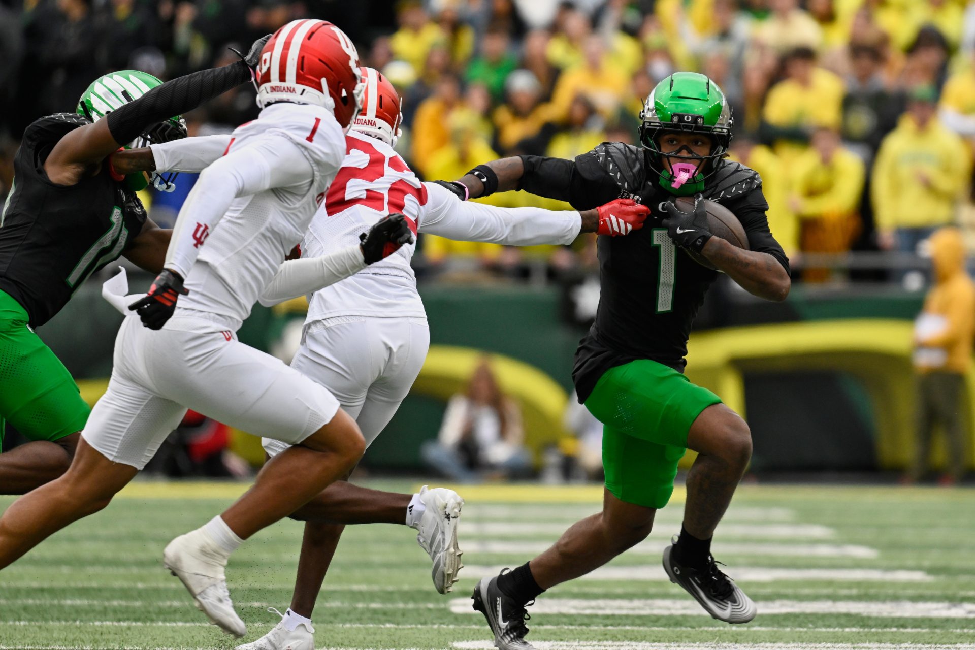Oregon Ducks wide receiver Dakorien Moore (1) runs with the ball against Indiana Hoosiers defensive backs Jamari Sharpe (22) and Amare Ferrell (1) during the fourth quarter at Autzen Stadium.