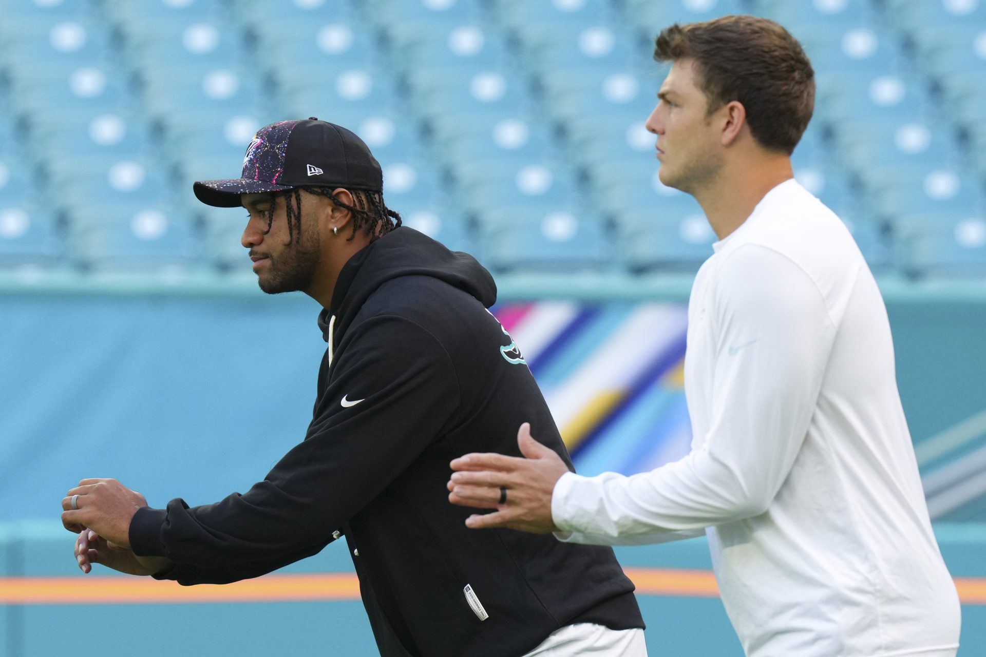 Miami Dolphins quarterbacks Tua Tagovailoa (1)  and quarterback Zach Wilson (0) warm up prior to a game against the Los Angeles Chargers at Hard Rock Stadium.