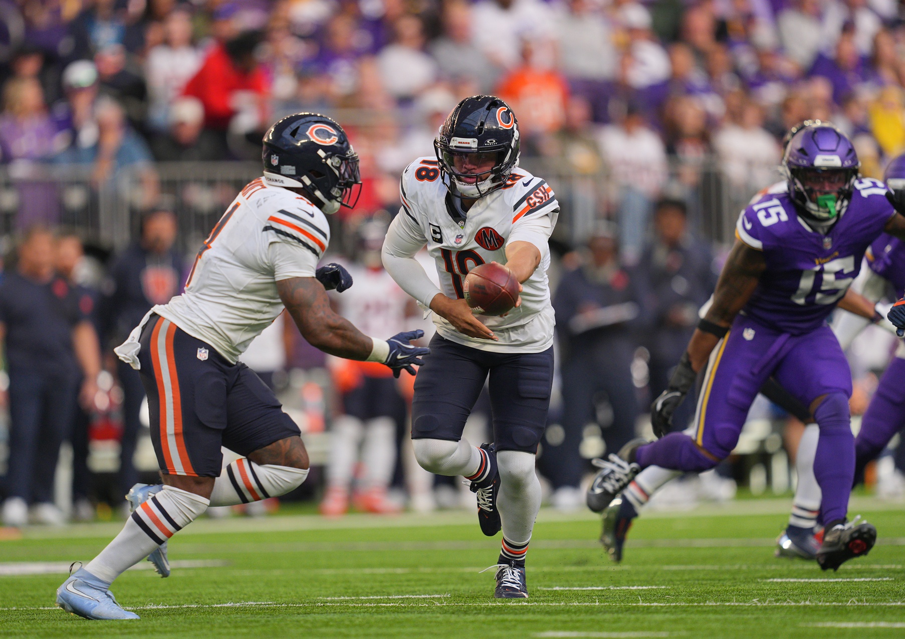 Chicago Bears quarterback Caleb Williams (18) hands the ball off to running back D'Andre Swift (4) during the third quarter against the Minnesota Vikings at U.S. Bank Stadium.