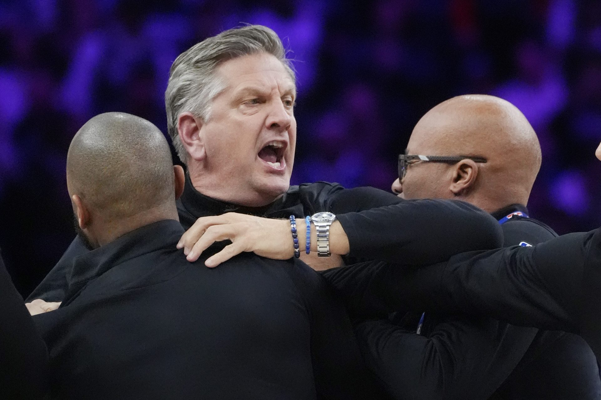 Staff restrains Minnesota Timberwolves head coach Chris Finch after a referee ejected him for chasing him down on a call for the Oklahoma City Thunder in the first quarter at Target Center.