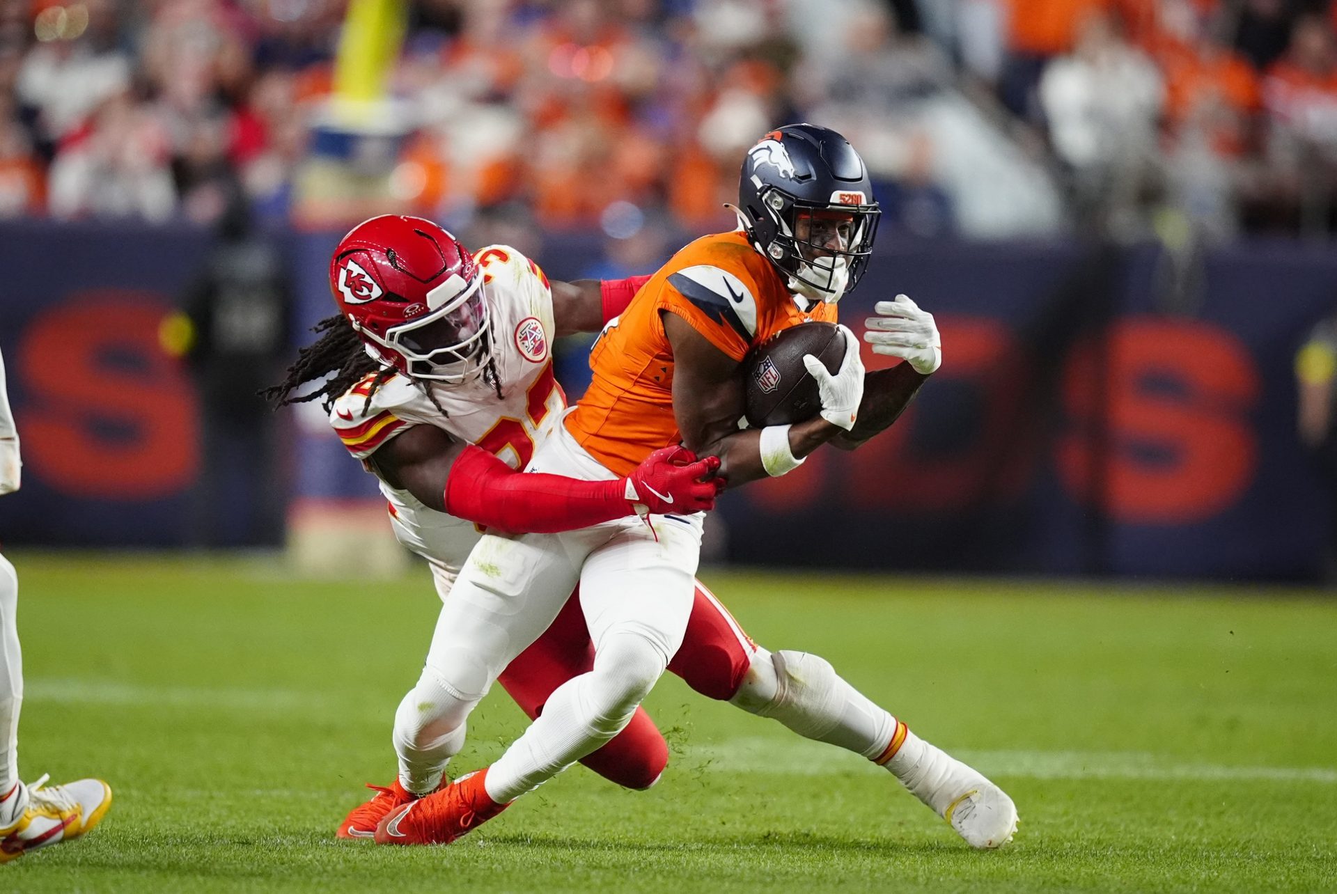Kansas City Chiefs linebacker Nick Bolton (32) tackles Denver Broncos wide receiver Courtland Sutton (14) in the fourth quarter at Empower Field at Mile High.