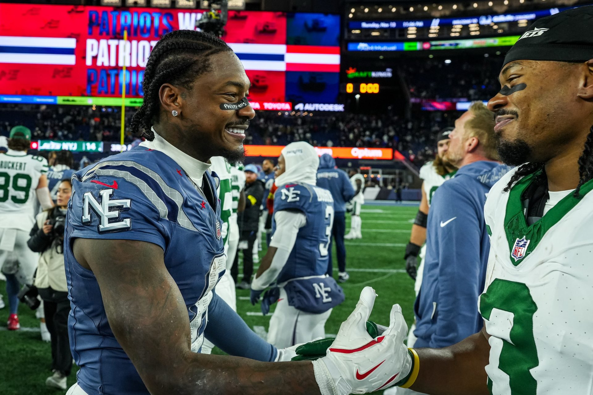 New England Patriots wide receiver Stefon Diggs (8) and New York Jets wide receiver John Metchie III (3) meet on the field after the game at Gillette Stadium.