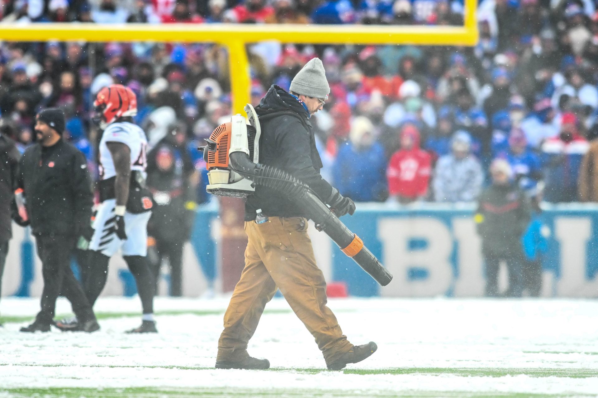 A Buffalo Bills grounds crewman clears snow from the field during a game against the Cincinnati Bengals at Highmark Stadium.