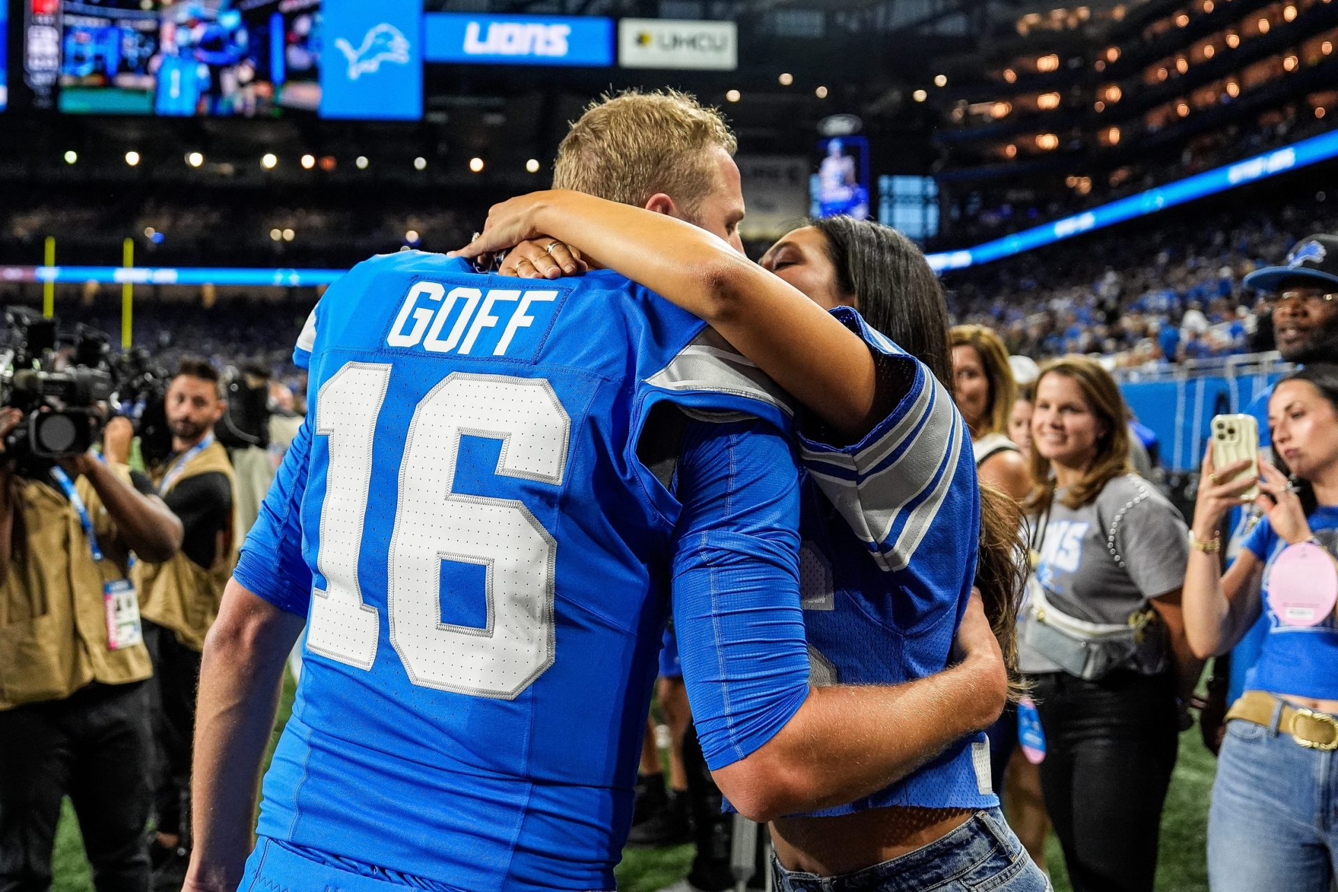 Detroit Lions quarterback Jared Goff hugs his wife Christen Harper during warmups before the Los Angeles Rams game at Ford Field in Detroit on Sunday, Sept. 8, 2024.