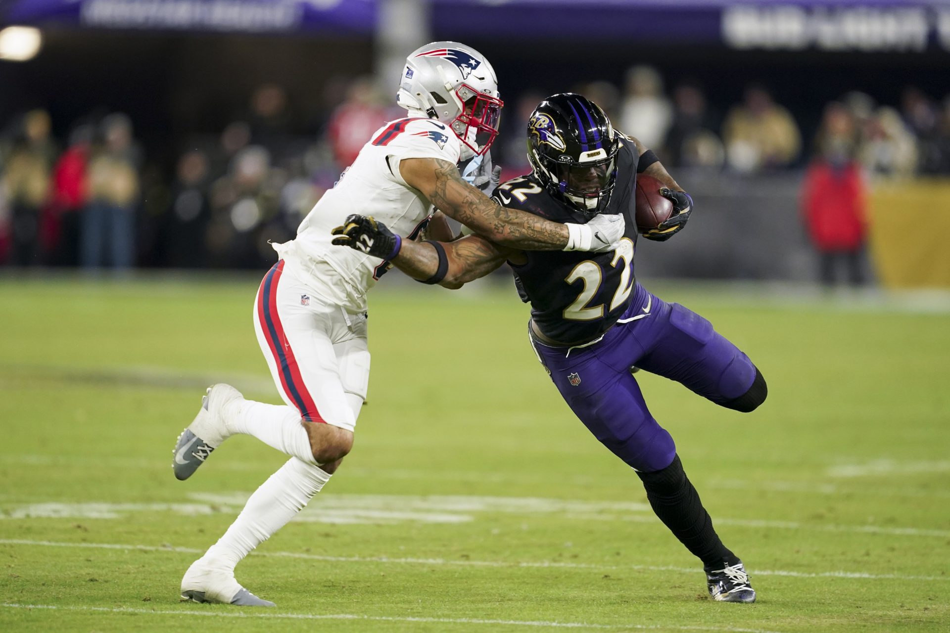Baltimore Ravens running back Derrick Henry (22) runs the ball against New England Patriots cornerback Christian Gonzalez (0) during the second half of the game at M&T Bank Stadium.