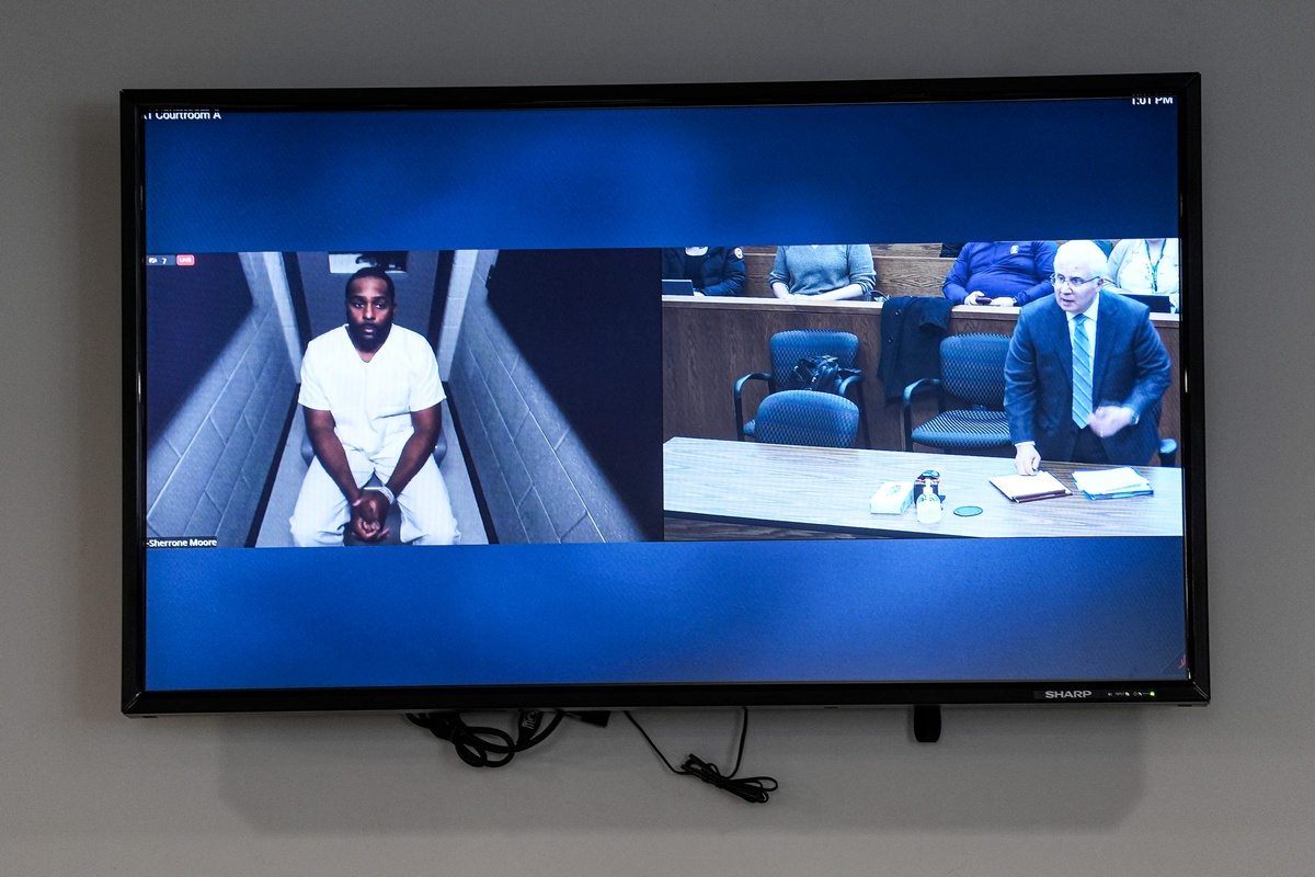 Former Michigan football head coach Sherrone Moore, left, and his attorney Joseph Simon, right, are pictured on a screen during Moore's arraignment at Washtenaw County 14A-1 District Court in Ann Arbor on Friday, Dec. 12, 2025.
