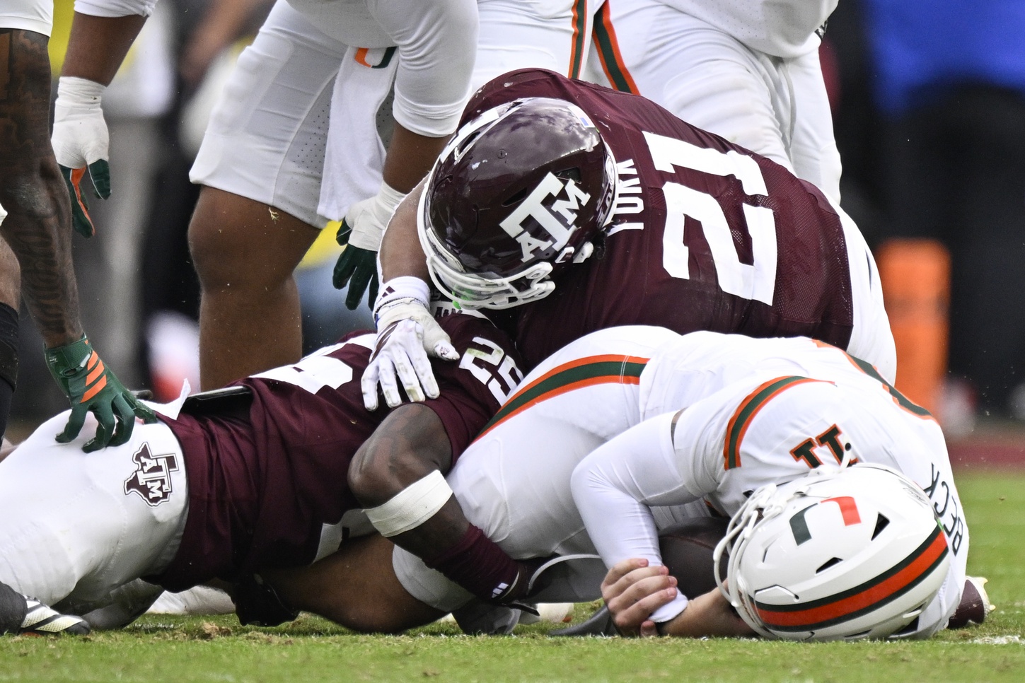 Texas A&M Aggies safety Dalton Brooks (25) and Texas A&M Aggies linebacker Taurean York (21) sack Miami Hurricanes quarterback Carson Beck (11) during first half of the first round game of the CFP National Playoff at Kyle Field.