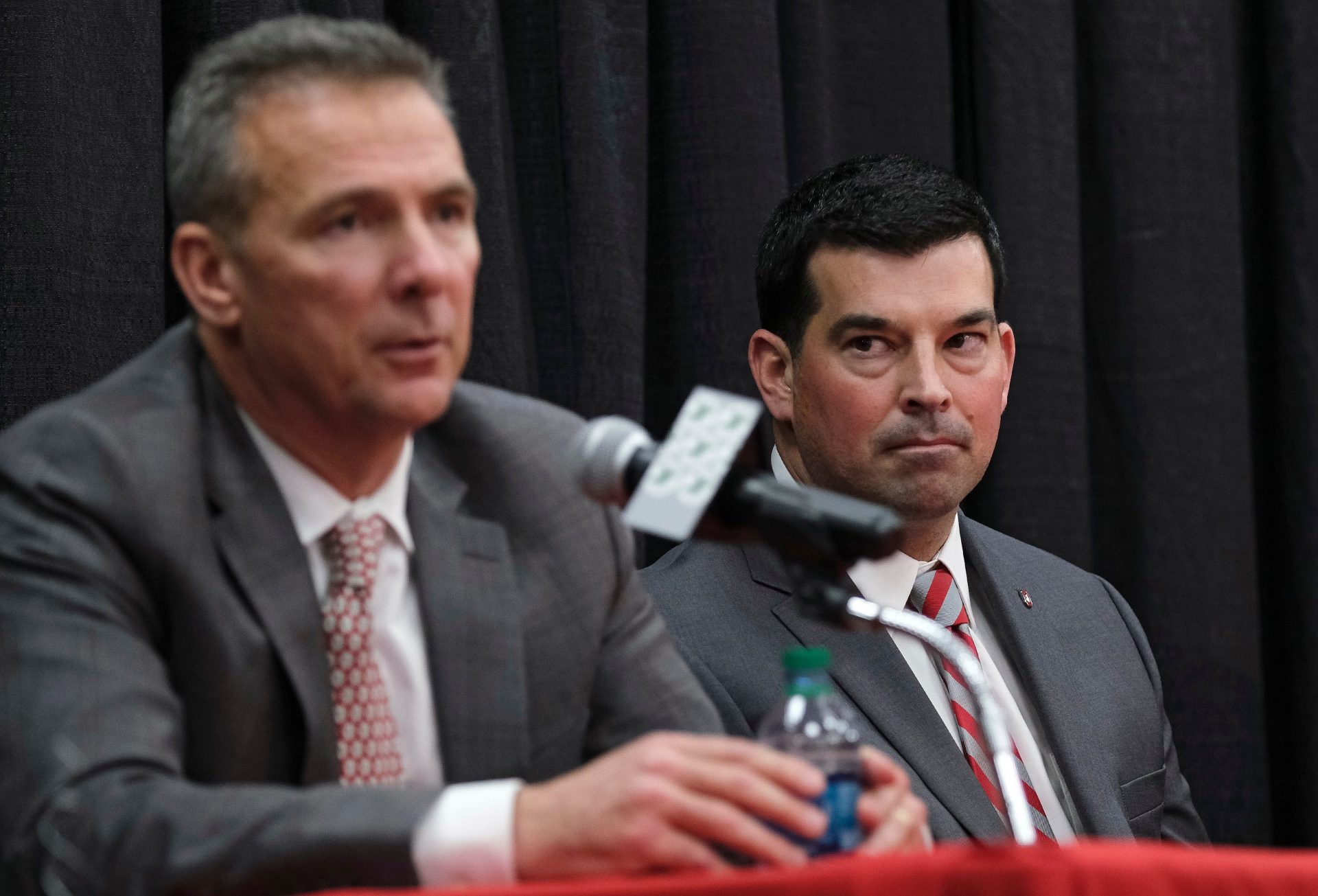 Ohio State Buckeyes offensive coordinator Ryan Day listens to head coach Urban Meyer during a press conference to announce Meyer's retirement and Day's hiring as head football coach at Ohio State's Fawcett Center in Columbus on Dec. 4, 2018. [Adam Cairns/Dispatch]