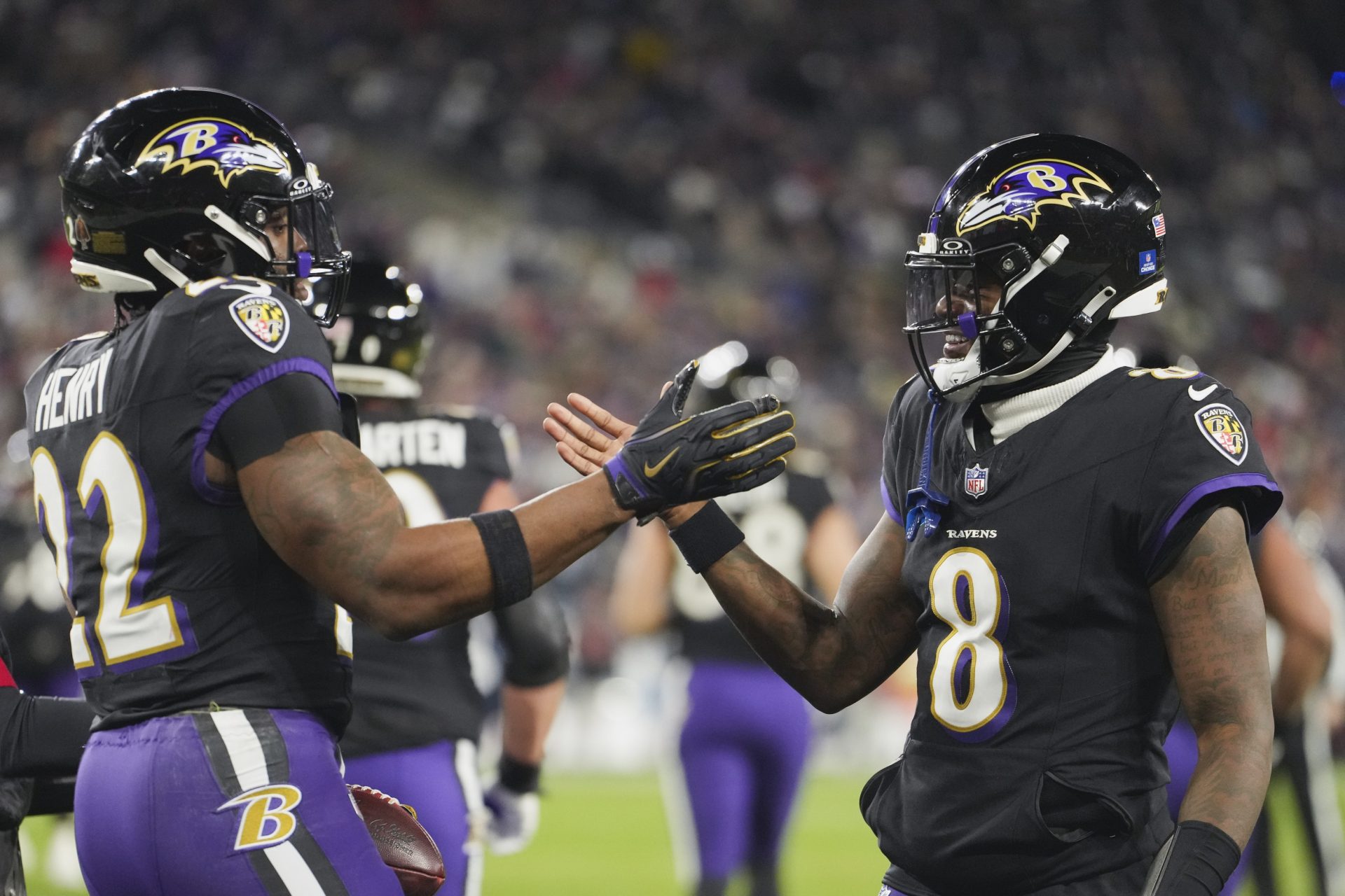 Baltimore Ravens quarterback Lamar Jackson (8) congratulates running back Derrick Henry (22) on a touchdown run against the New England Patriots during the first quarter at M&T Bank Stadium.