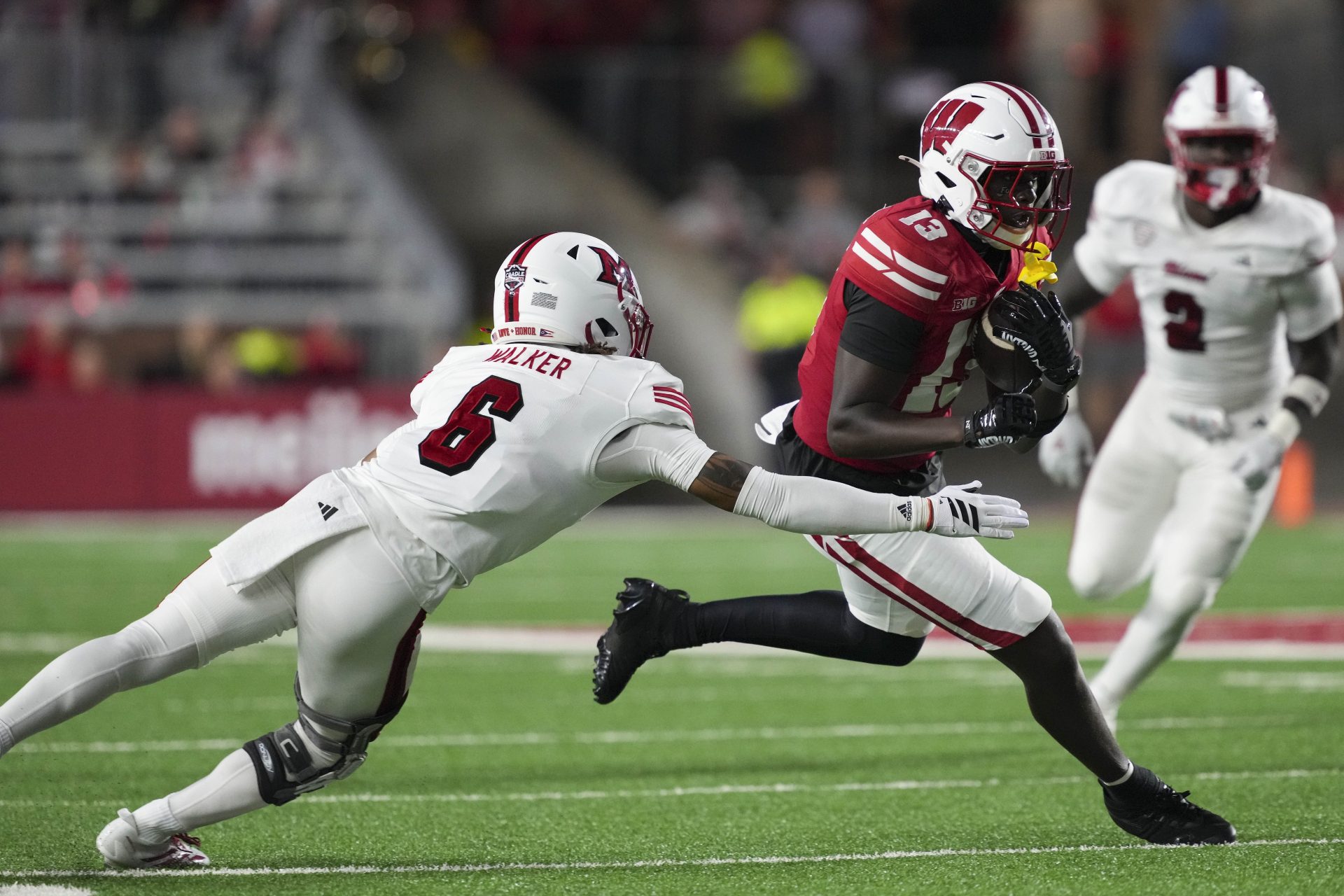 Wisconsin Badgers wide receiver Eugene Hilton Jr. (13) rushes with the football against Miami (OH) RedHawks defensive back Adrian Walker Jr. (6) during the third quarter at Camp Randall Stadium.