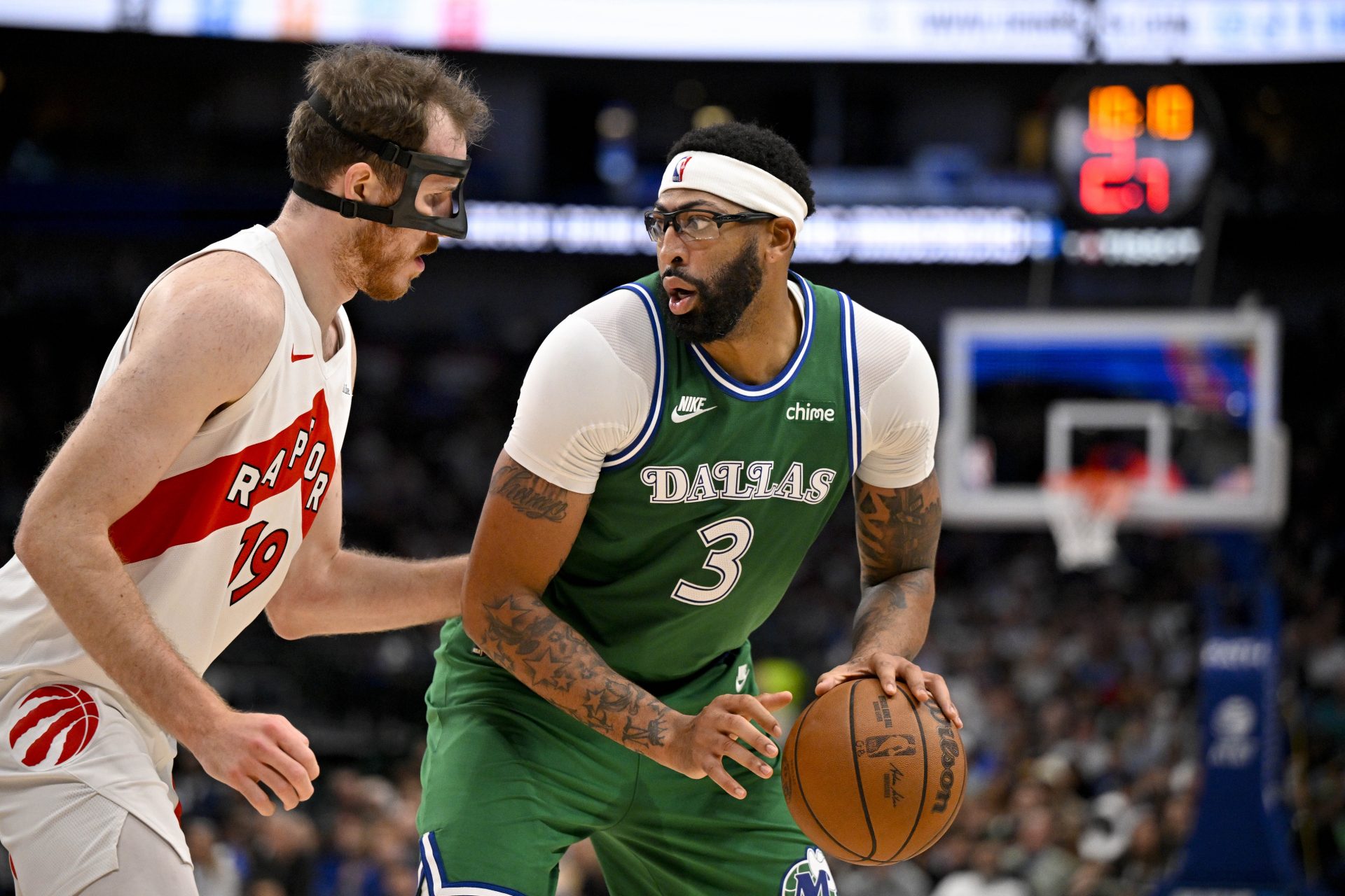 Dallas Mavericks forward Anthony Davis (3) looks to move the ball past Toronto Raptors center Jakob Poeltl (19) during the game between the Mavericks and the Raptors at the American Airlines Center.