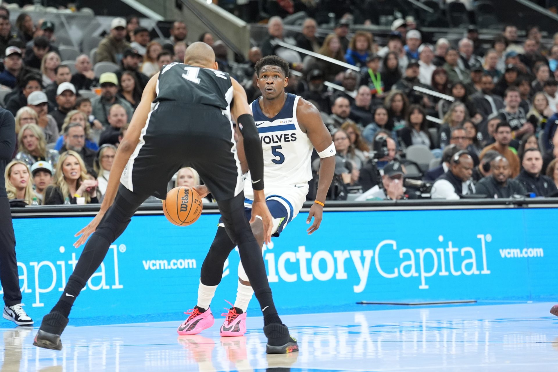 Minnesota Timberwolves guard Anthony Edwards (5) dribbles in front of San Antonio Spurs forward Victor Wembanyama (1) in the first half at Frost Bank Center.
