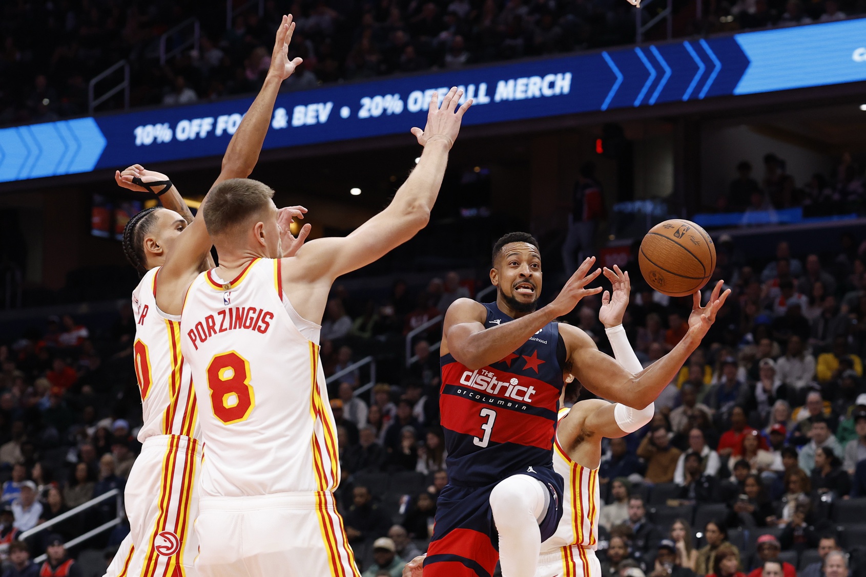 Washington Wizards guard CJ McCollum (3) loses the ball while driving to the basket as Atlanta Hawks center Kristaps Porzingis (8) defends in the second half at Capital One Arena.