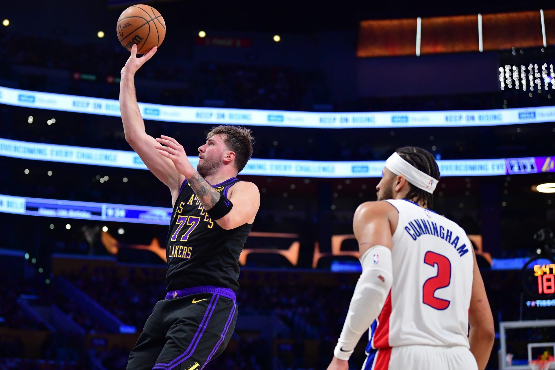 Los Angeles Lakers guard Luka Doncic (77) shoots against Detroit Pistons guard Cade Cunningham (2) during the second half at Crypto.com Arena.