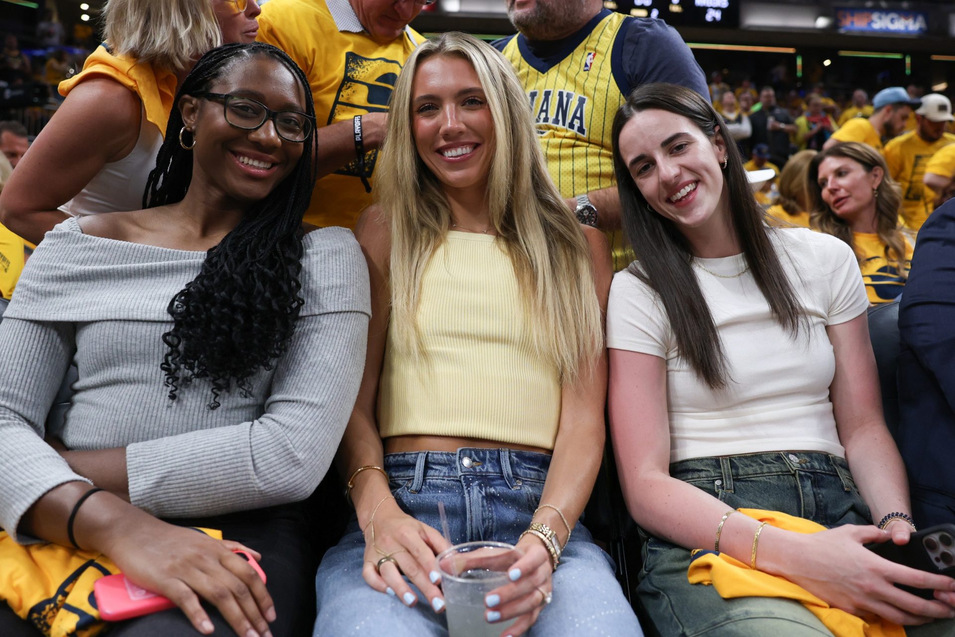 Indiana Fever players Aliyah Boston (left), Lexie Hull and Caitlin Clark are in attendance during game six of the eastern conference finals between the Indiana Pacers and the New York Knicks for the 2025 NBA Playoffs at Gainbridge Fieldhouse.
