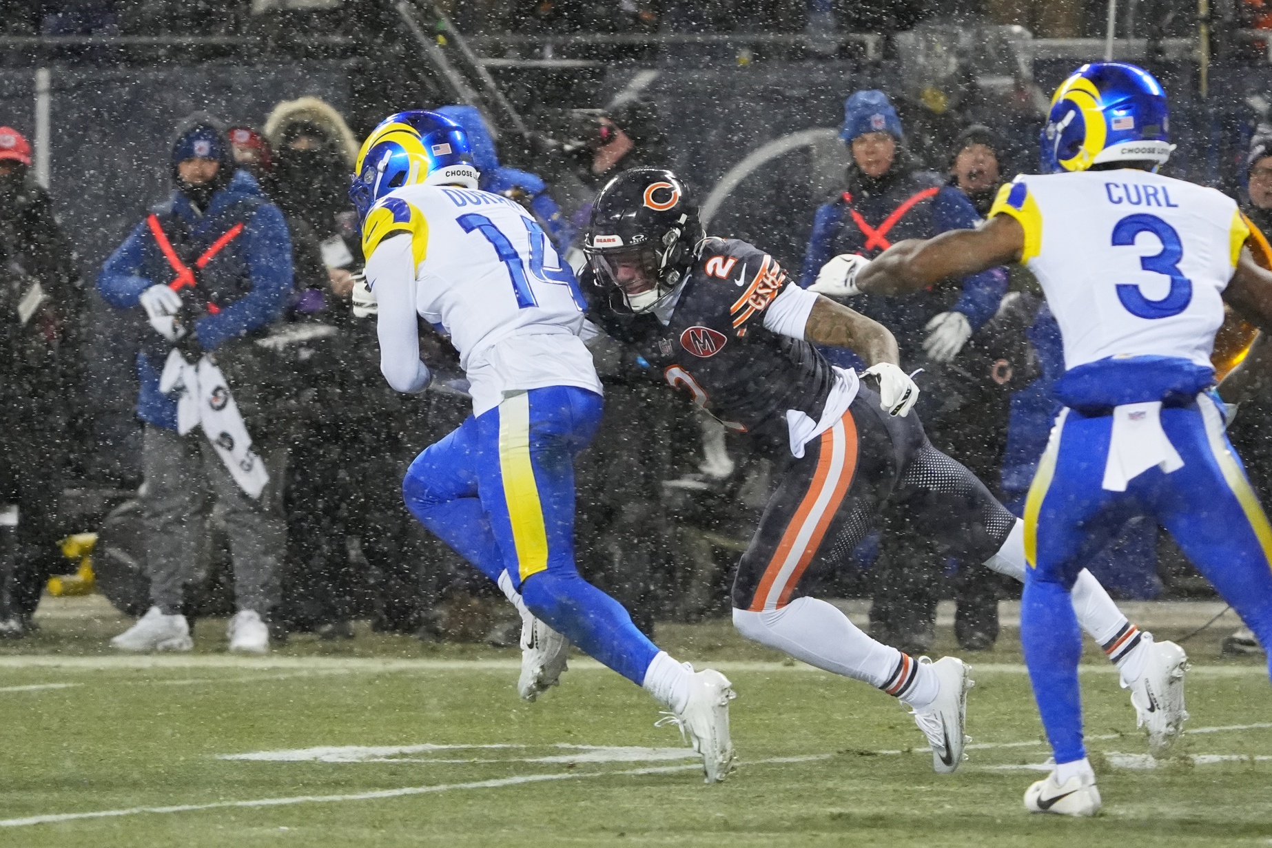 Los Angeles Rams cornerback Cobie Durant (14) runs with the ball against Chicago Bears wide receiver DJ Moore (2) after intercepting a pass thrown by quarterback Caleb Williams (not pictured) during the first quarter of an NFC Divisional Round game at Soldier Field.
