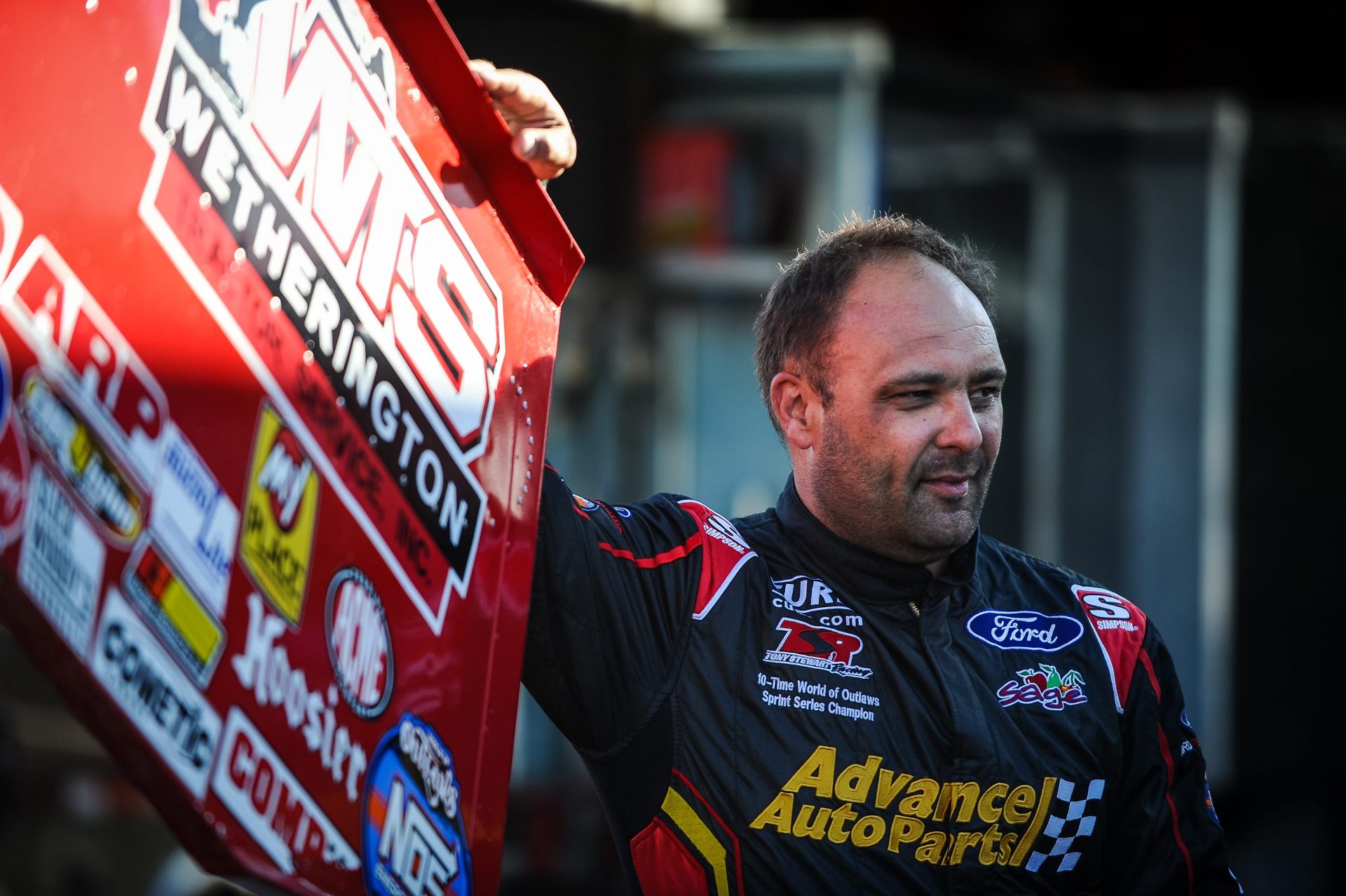 Donny Schatz waits by his car for World of Outlaws action during the first night of the Jim 