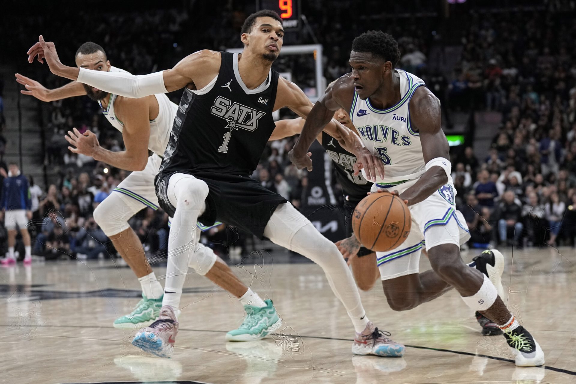 Minnesota Timberwolves guard Anthony Edwards (5) drives to the basket against San Antonio Spurs forward Victor Wembanyama (1) during the second half at Frost Bank Center.