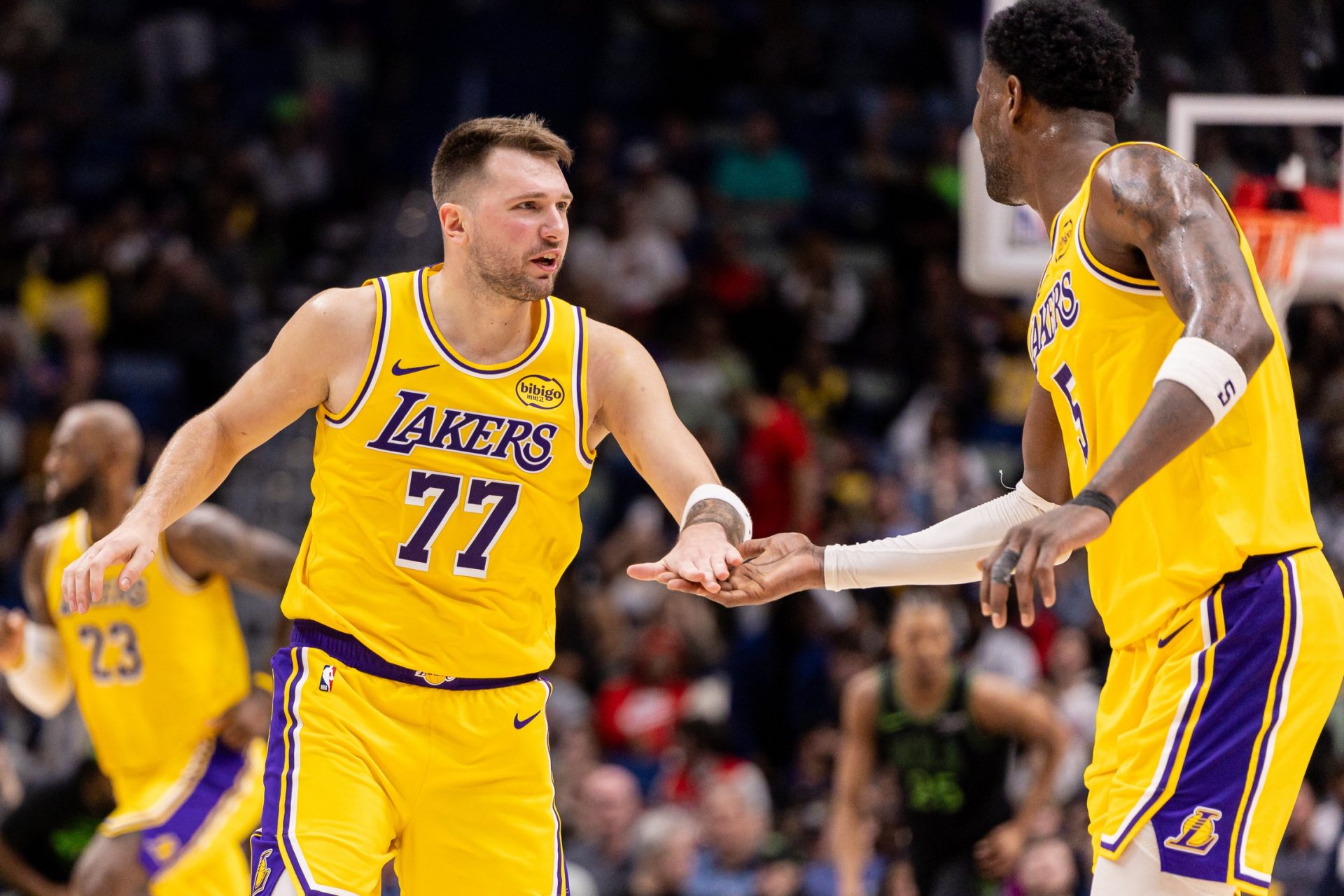 Los Angeles Lakers forward/guard Luka Doncic (77) slaps hands with center Deandre Ayton (5) after a play against the New Orleans Pelicans during the second half at Smoothie King Center.