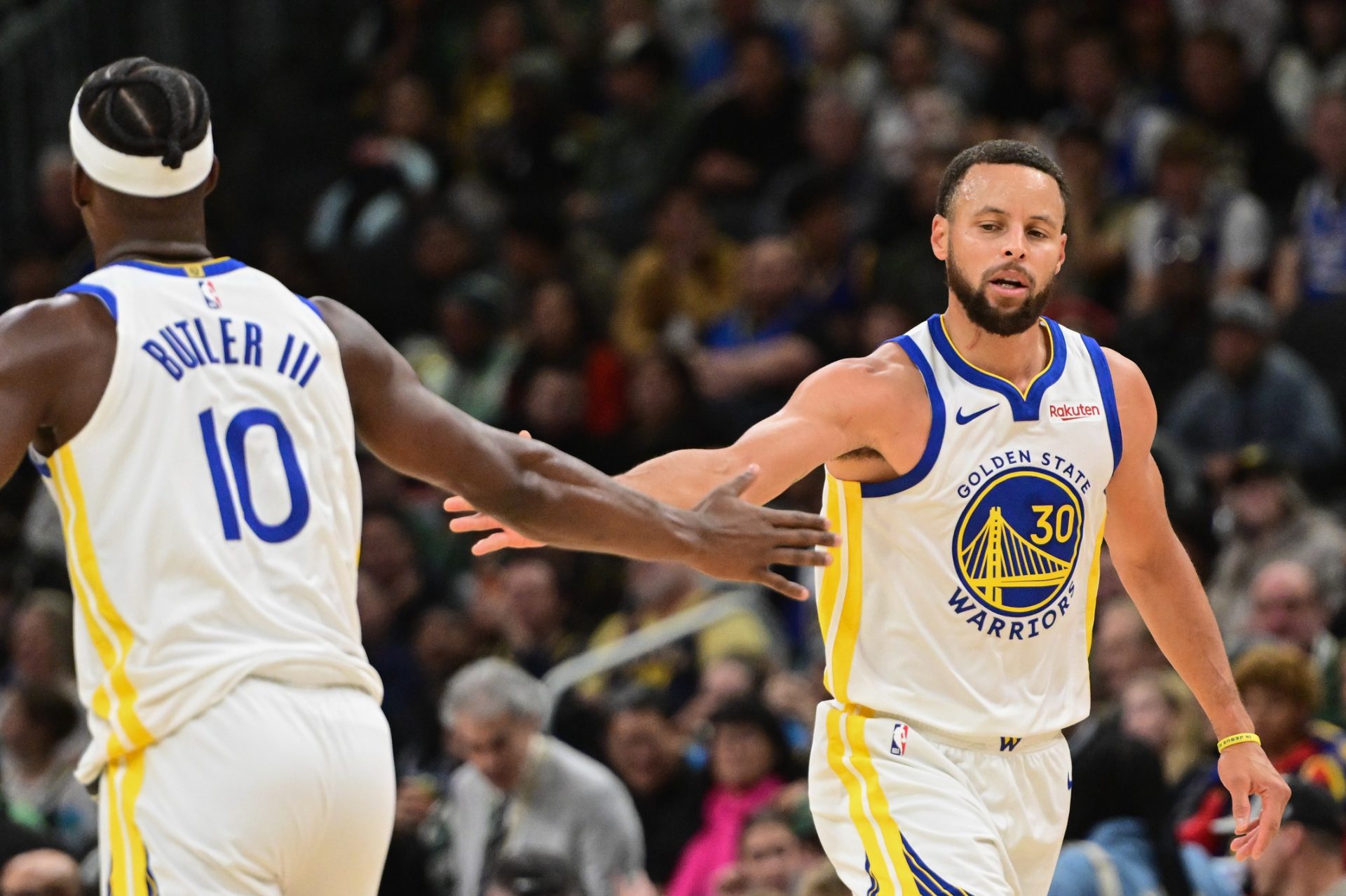 Golden State Warriors guard Stephen Curry (30) reacts with forward Jimmy Butler (10) after scoring a basket in the 3rd quarter against the Milwaukee Bucks at Fiserv Forum.