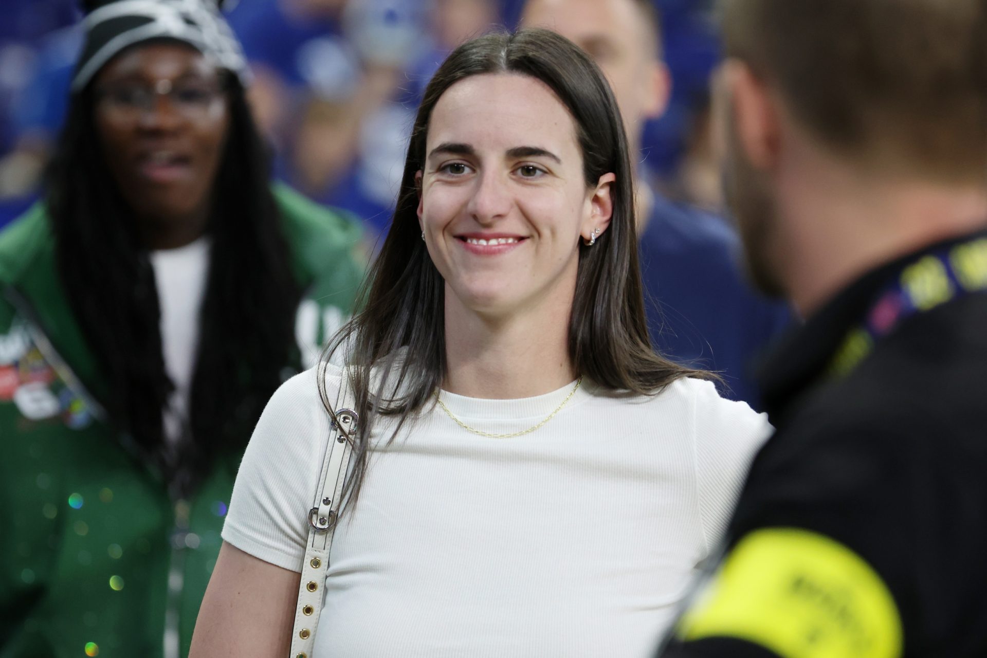 Caitlin Clark looks on from the sideline during warmups before the game between the Las Vegas Raiders and the Indianapolis Colts at Lucas Oil Stadium.