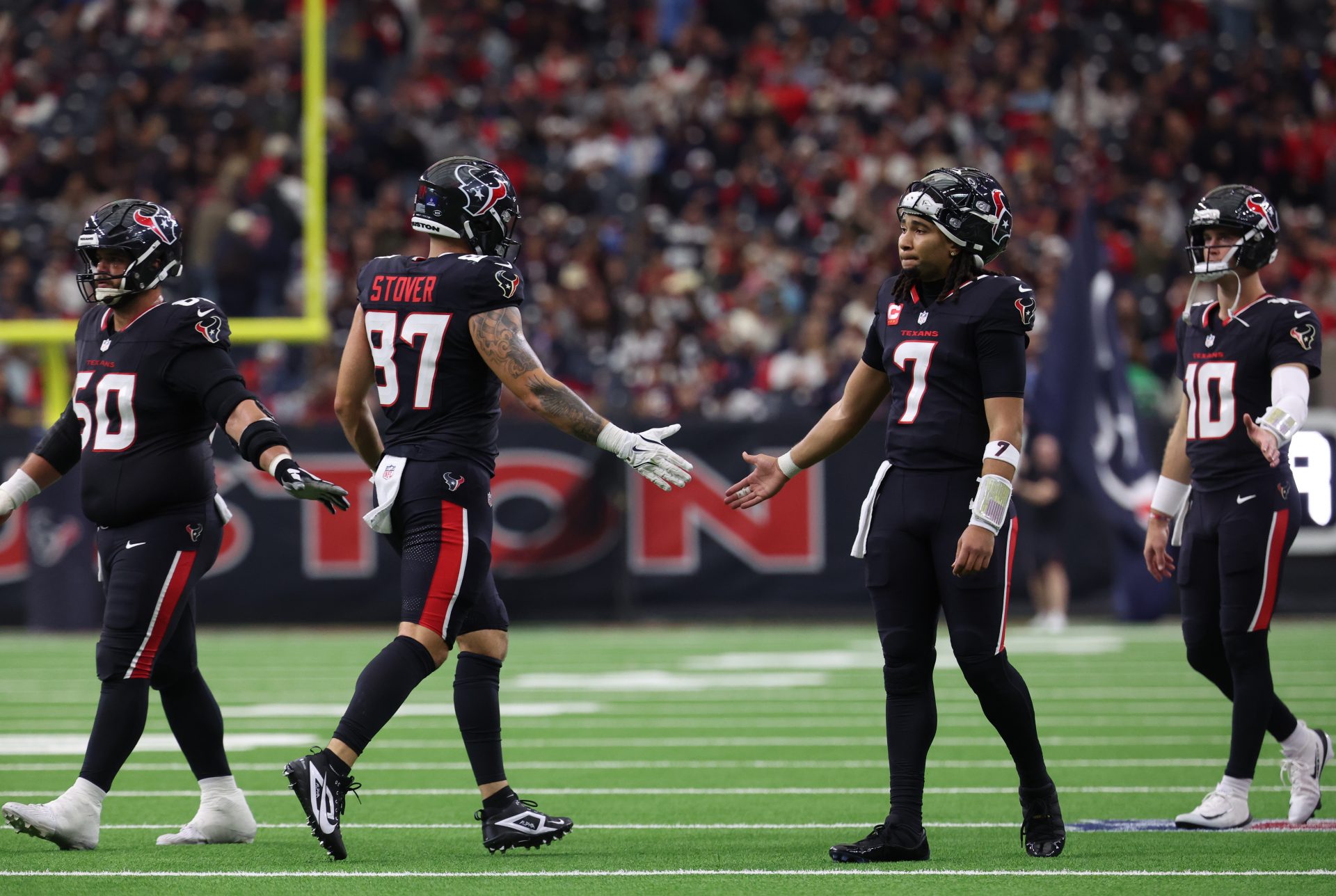 Houston Texans quarterback C.J. Stroud (7) high-fives tight end Cade Stover (87) during the second quarter against the Arizona Cardinals at NRG Stadium.