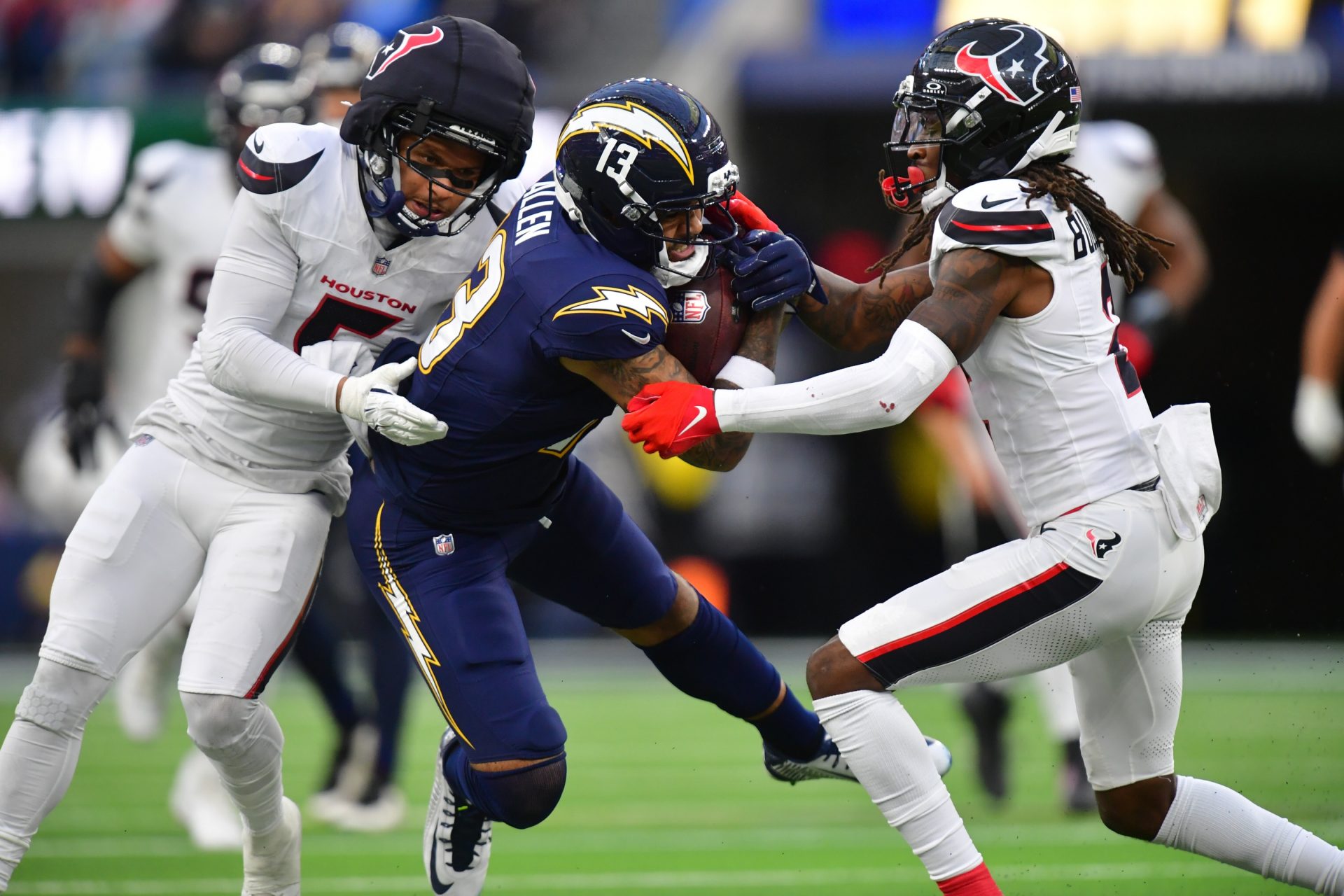Los Angeles Chargers wide receiver Keenan Allen (13) runs after the catch as Houston Texans safety Jalen Pitre (5) and safety Calen Bullock (2) defend during the second half at SoFi Stadium.