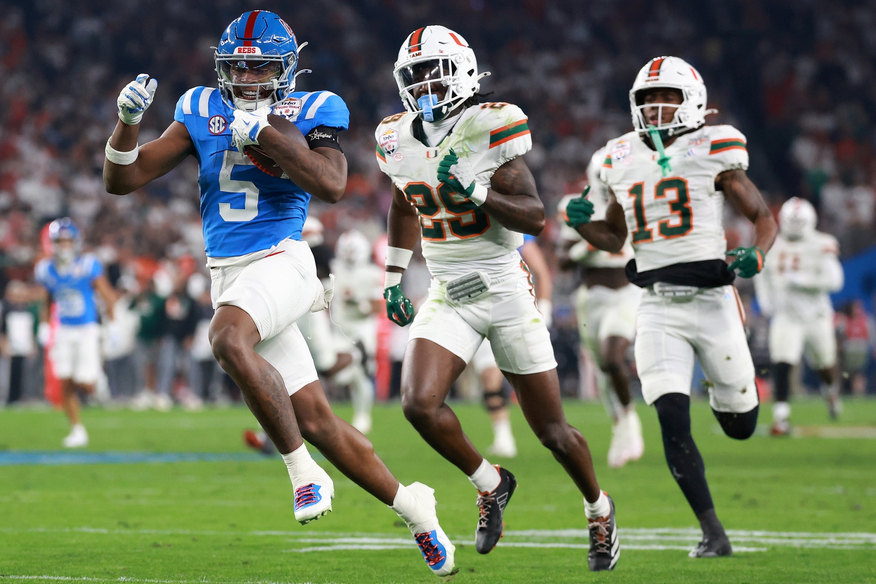 Mississippi Rebels running back Kewan Lacy (5) rushes the ball for a touchdown against Miami Hurricanes defensive back Jr. Romanas Frederique (29) in the first half during the 2026 Fiesta Bowl and semifinal game of the College Football Playoff at State Farm Stadium.