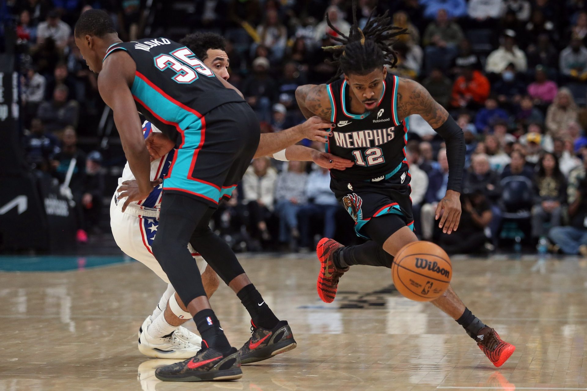 Memphis Grizzlies guard Ja Morant (12) dribbles around a screen set by center Christian Koloko (35) on Philadelphia 76ers guard Jared McCain (20) during the fourth quarter at FedExForum.