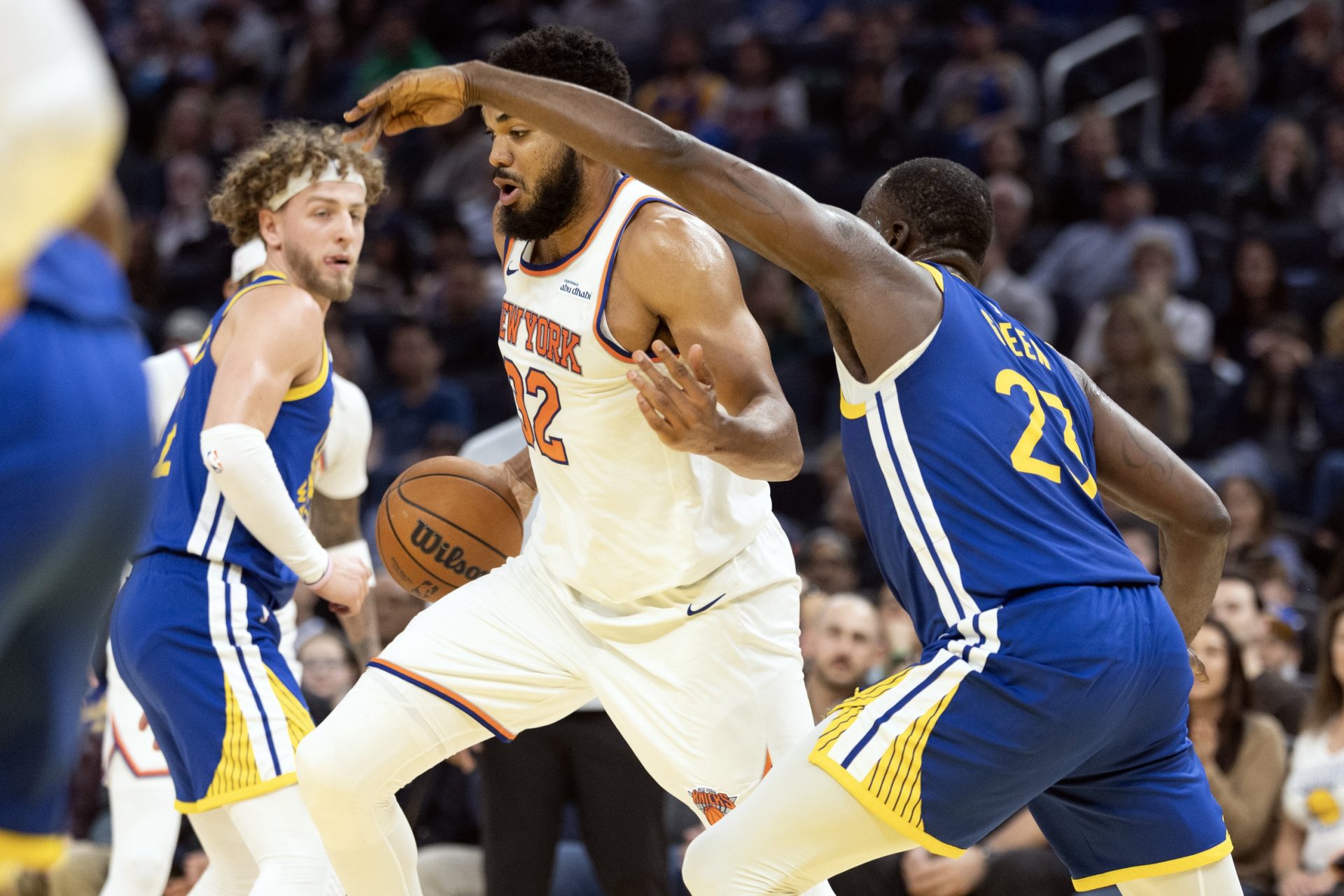New York Knicks center Karl-Anthony Towns (32) dribbles past Golden State Warriors forward Draymond Green (23) during the second quarter at Chase Center.