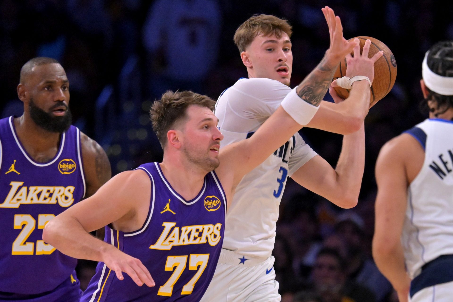Dallas Mavericks forward Cooper Flagg (32) is defended by Los Angeles Lakers guard Luka Doncic (77) in the first half at Crypto.com Arena.