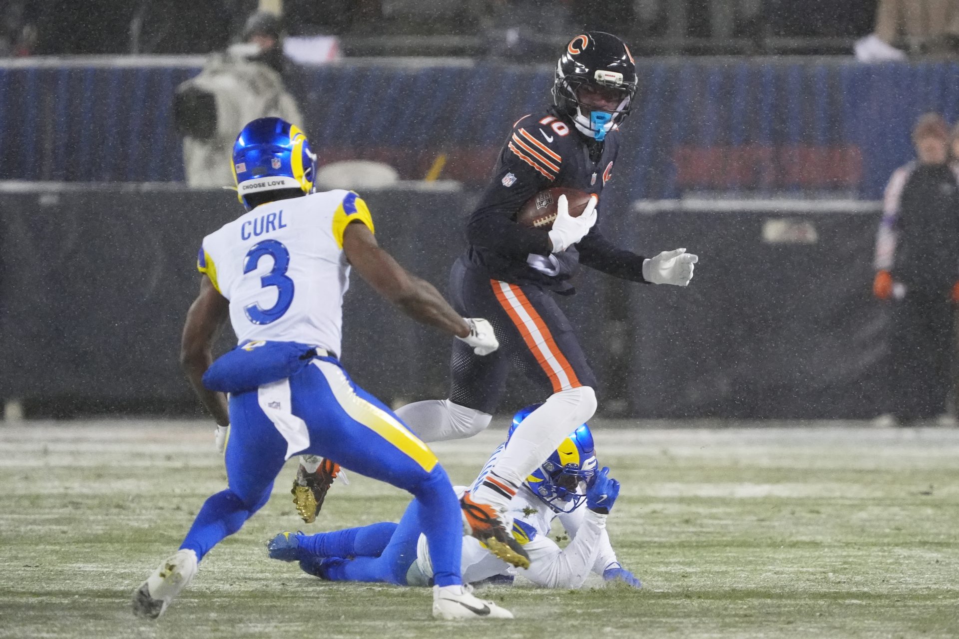 Chicago Bears wide receiver Luther Burden III (10) runs after the catch against Los Angeles Rams cornerback Darious Williams (31) and safety Kam Curl (3) during the second quarter of an NFC Divisional Round game at Soldier Field.
