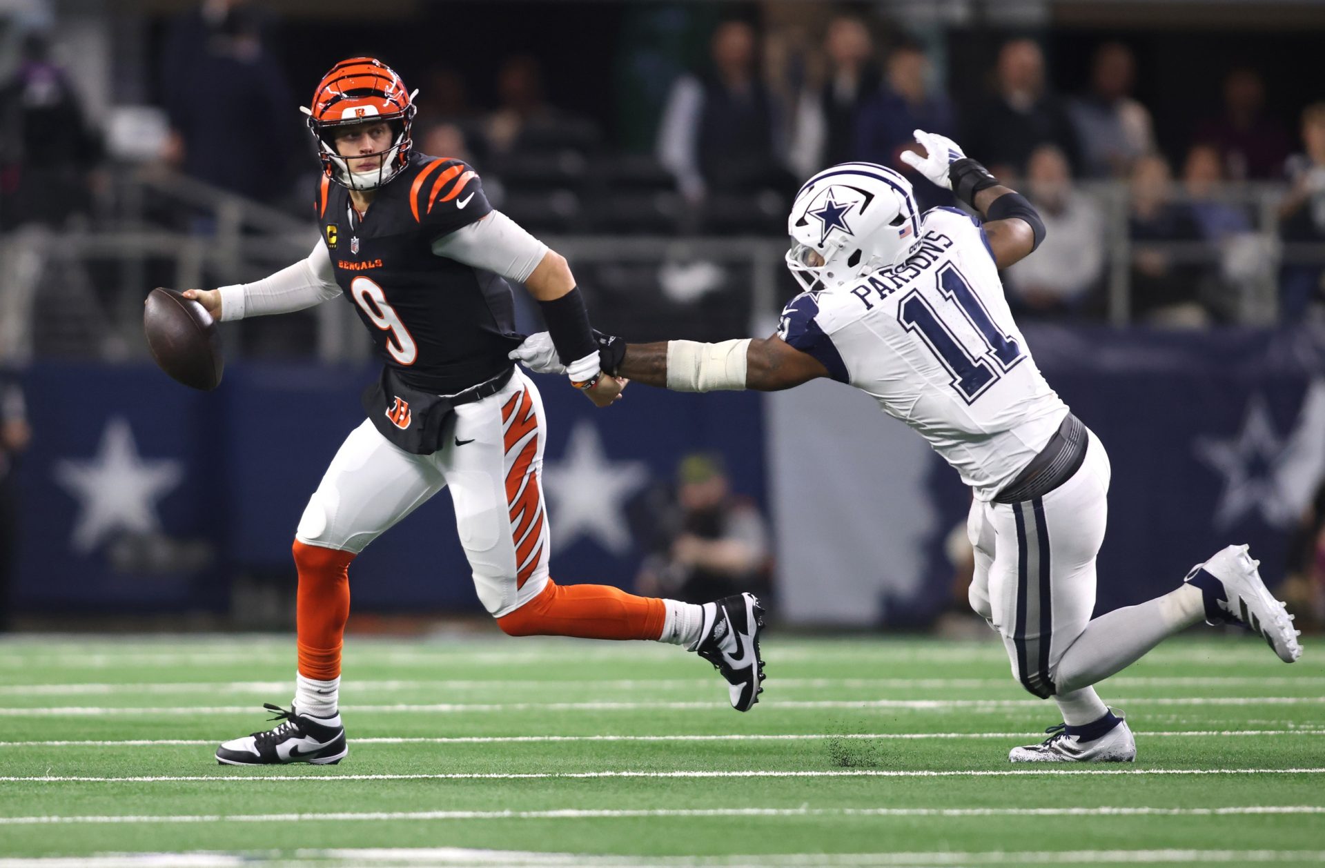 Cincinnati Bengals quarterback Joe Burrow (9) avoids the tackle of Dallas Cowboys linebacker Micah Parsons (11) in the second half  at AT&T Stadium.