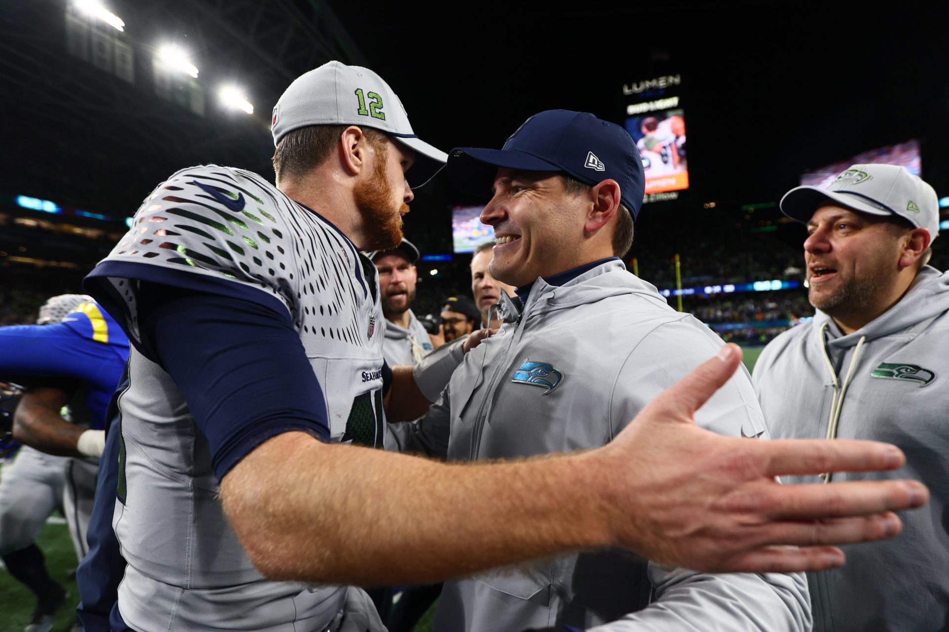 Seattle Seahawks head coach Mike MacDonald embraces quarterback Sam Darnold (14) after defeating the Los Angeles Rams in overtime at Lumen Field.